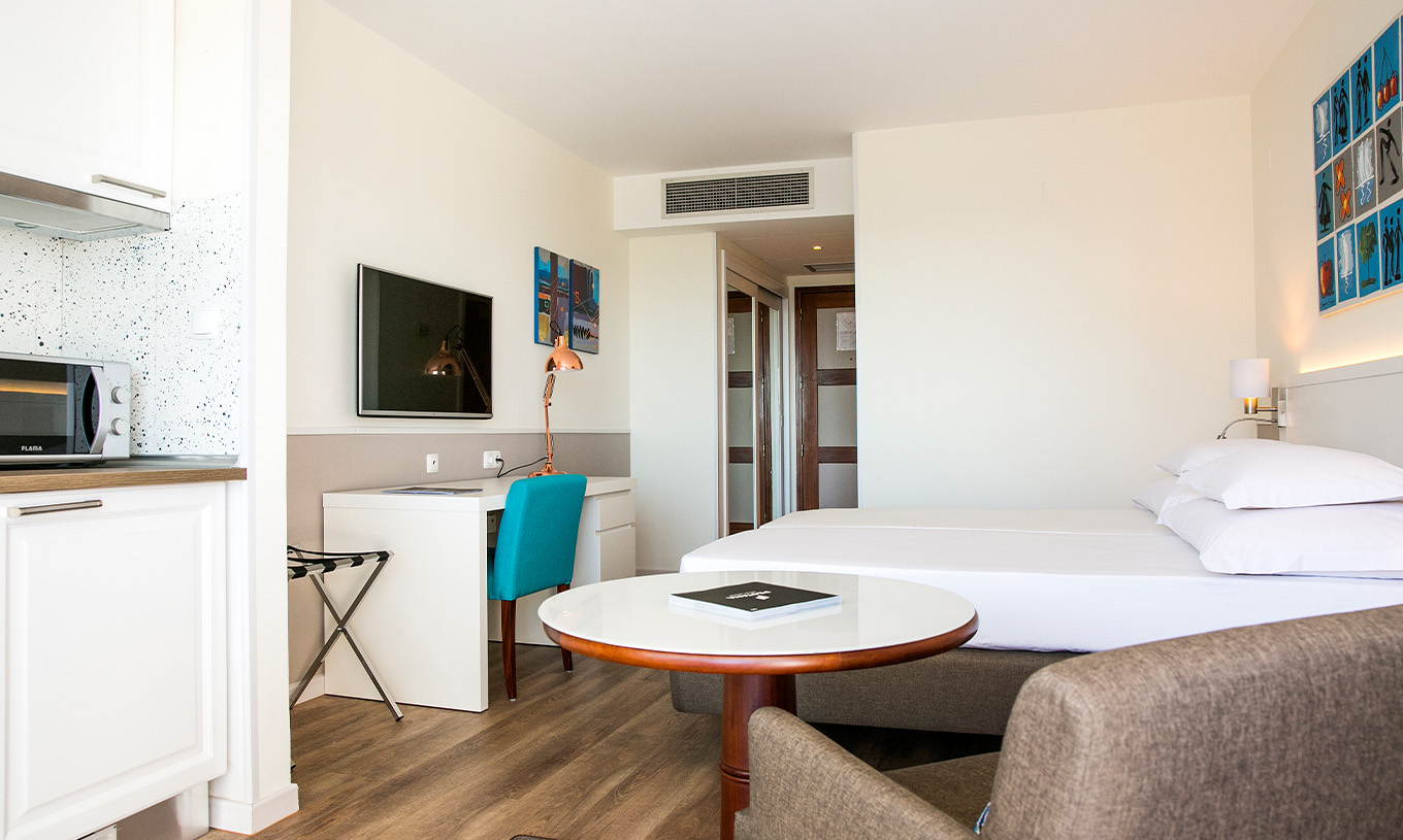 Das Deluxe-Zimmer mit Meerblick im Pestana Cascais hat zwei Einzelbetten, TV, Schreibtisch und eine Kitchenette