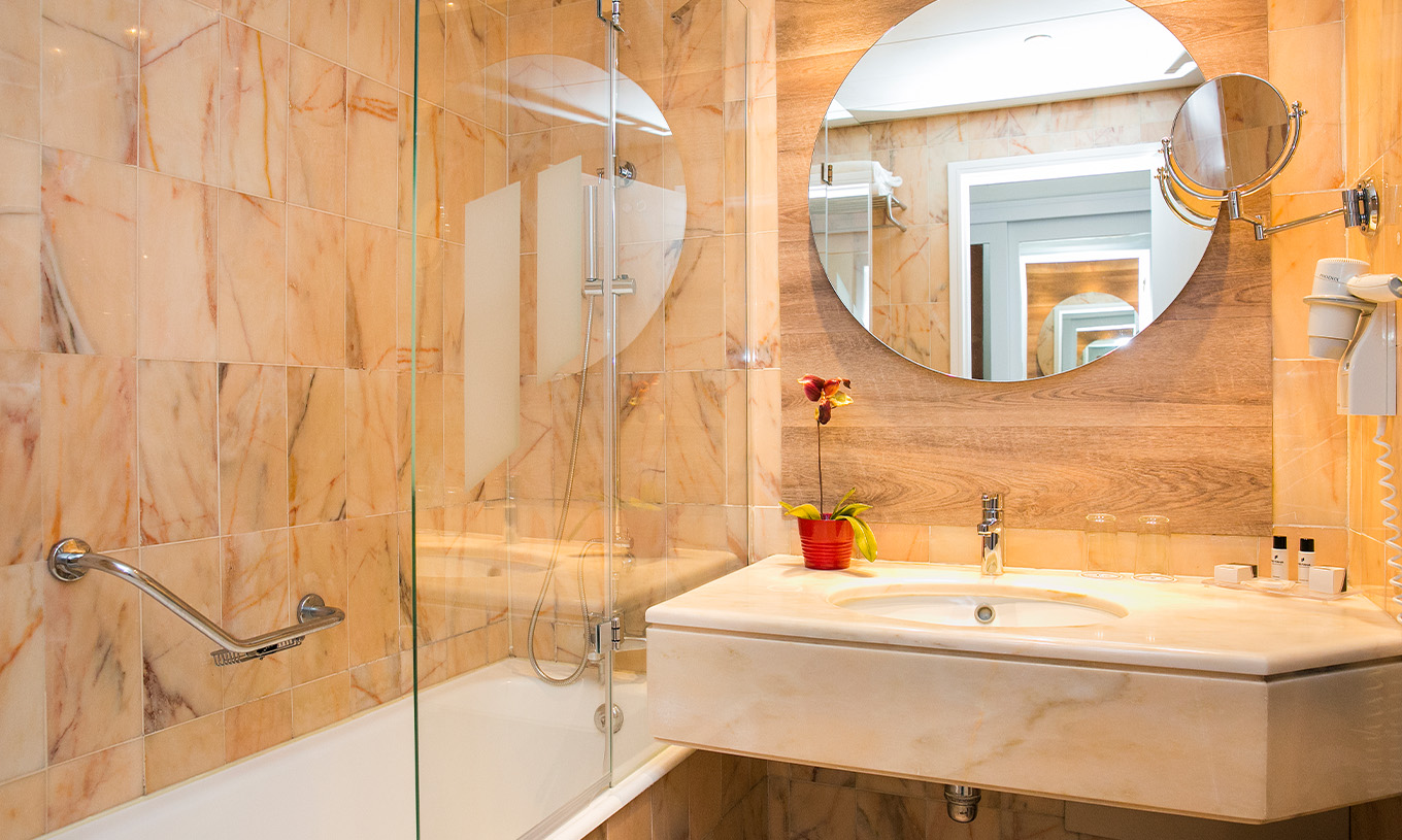 Die Deluxe Suite im Pestana Cascais hat ein Badezimmer mit Spiegel, Waschbecken und Dusche