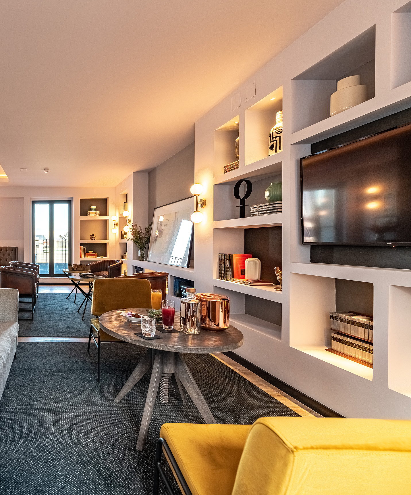 Lounge mit Sofas, Stühlen, Tischen, Bildern, Fernseher, Teppichen und Dekorationsgegenständen mit Stadtblick