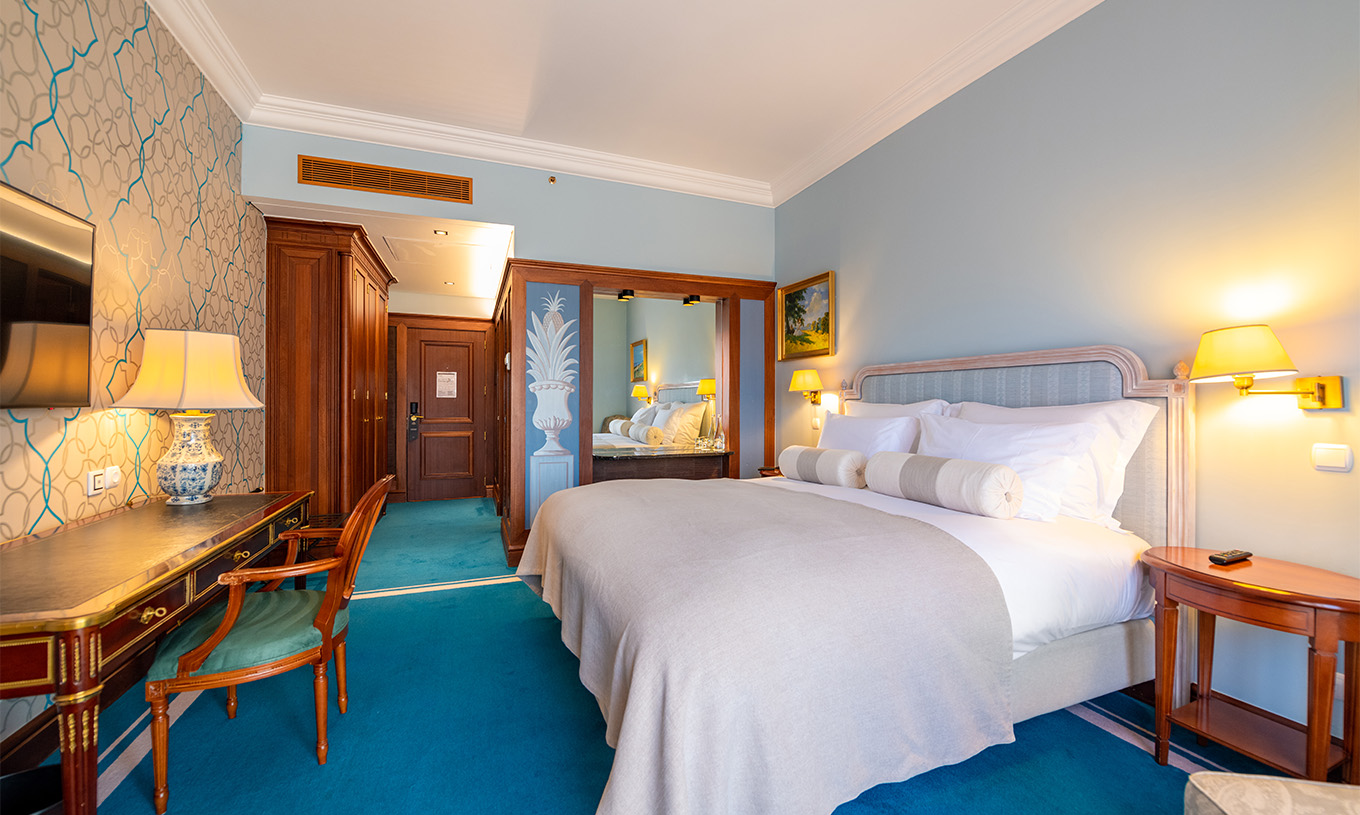 Das Premium Balkon Zimmer im Pestana Palace Lisboa hat ein Doppelbett, Holzwände und einen Spiegel