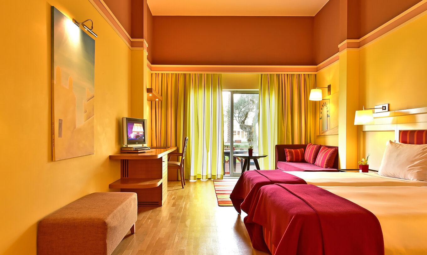 Das Superior Doppelzimmer mit Poolblick hat zwei Betten, ein Bild an der Wand und einen Sofa