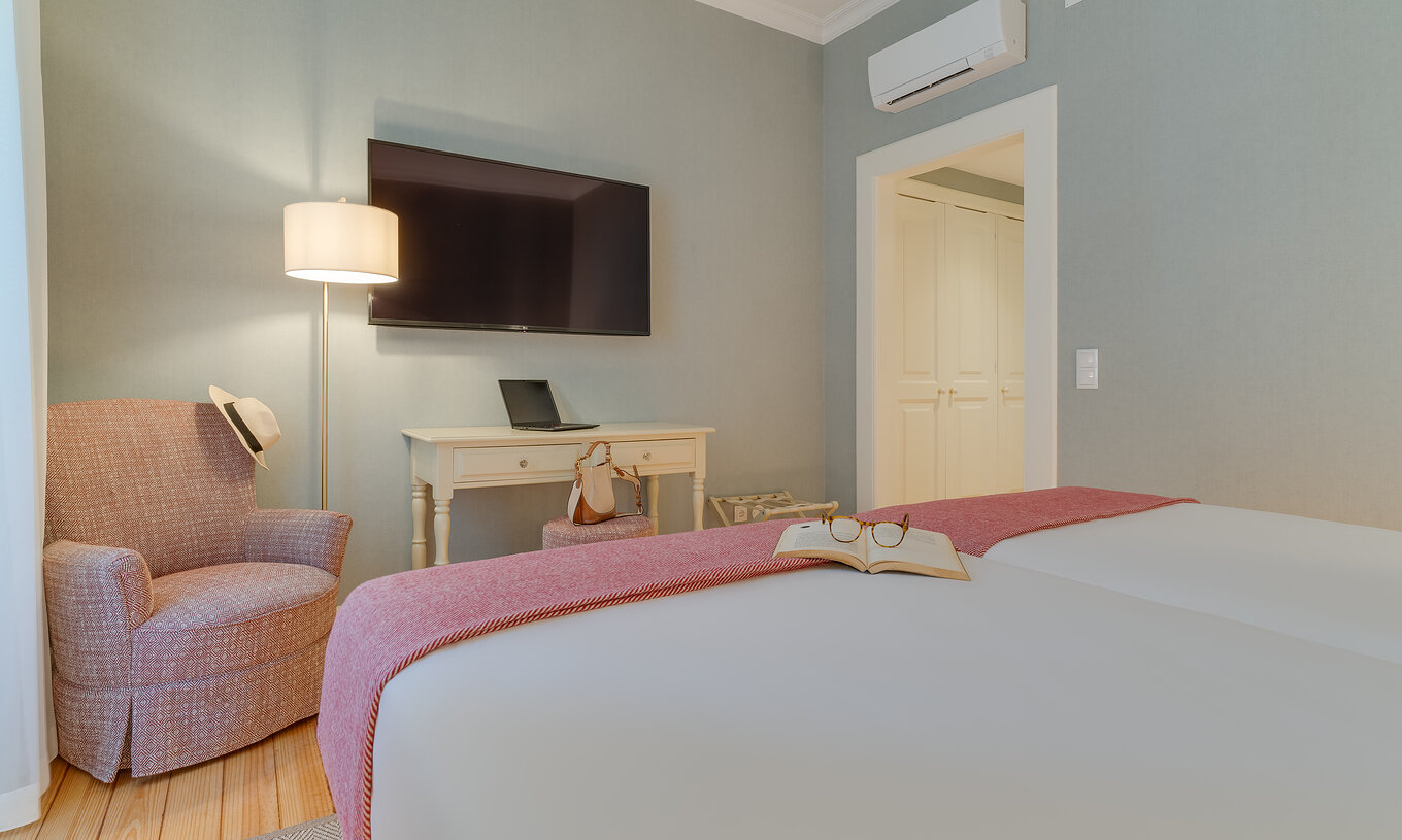 Klassisches Zimmer Innenblick im Pestana Quinta Perestrello hat einen Fernseher vor dem Bett, einen Sessel und ein Möbelstück