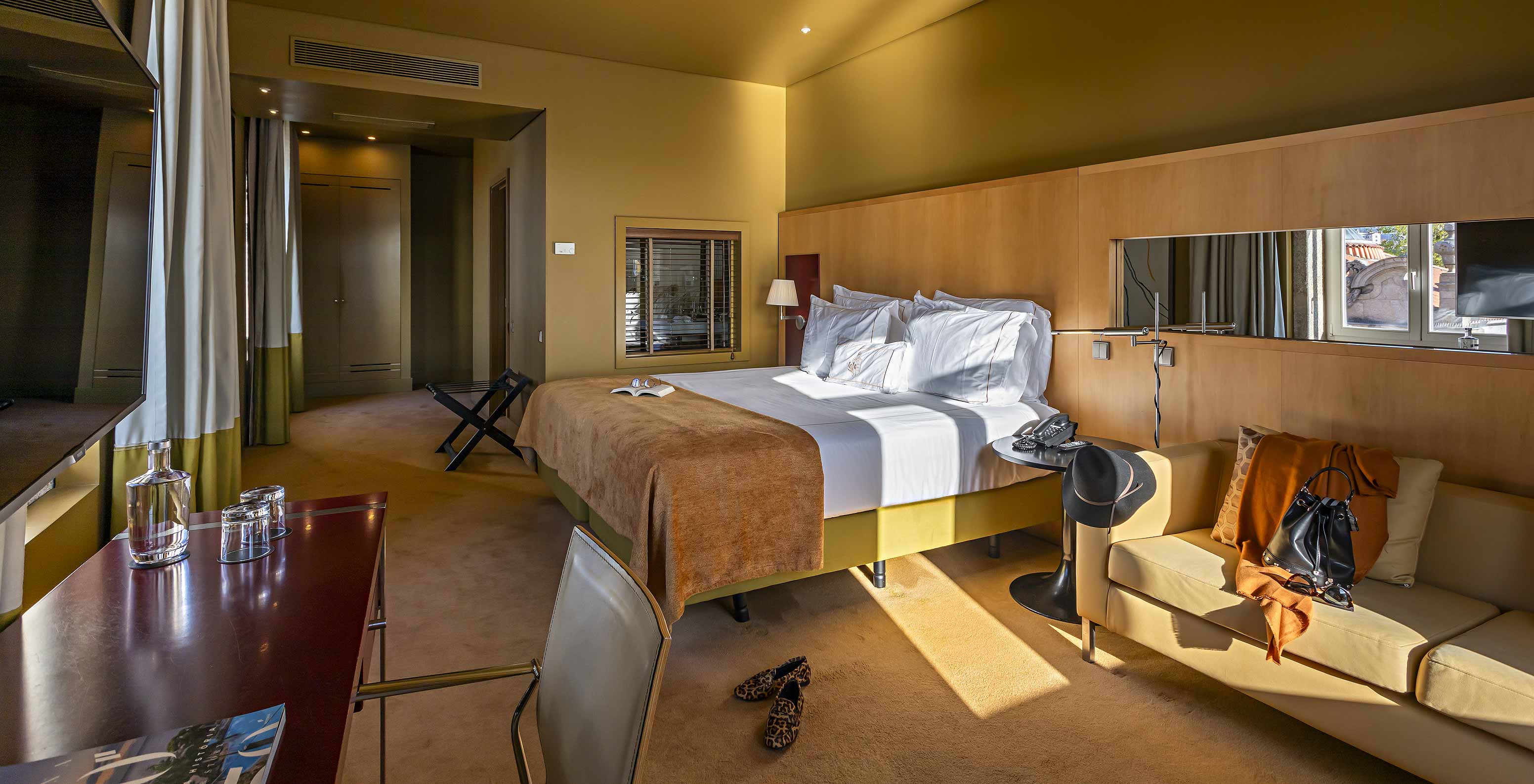 Das Deluxe Grand View verfügt über ein Doppelbett mit einer camel-farbenen Decke, ein sofa und einen Schreibtisch