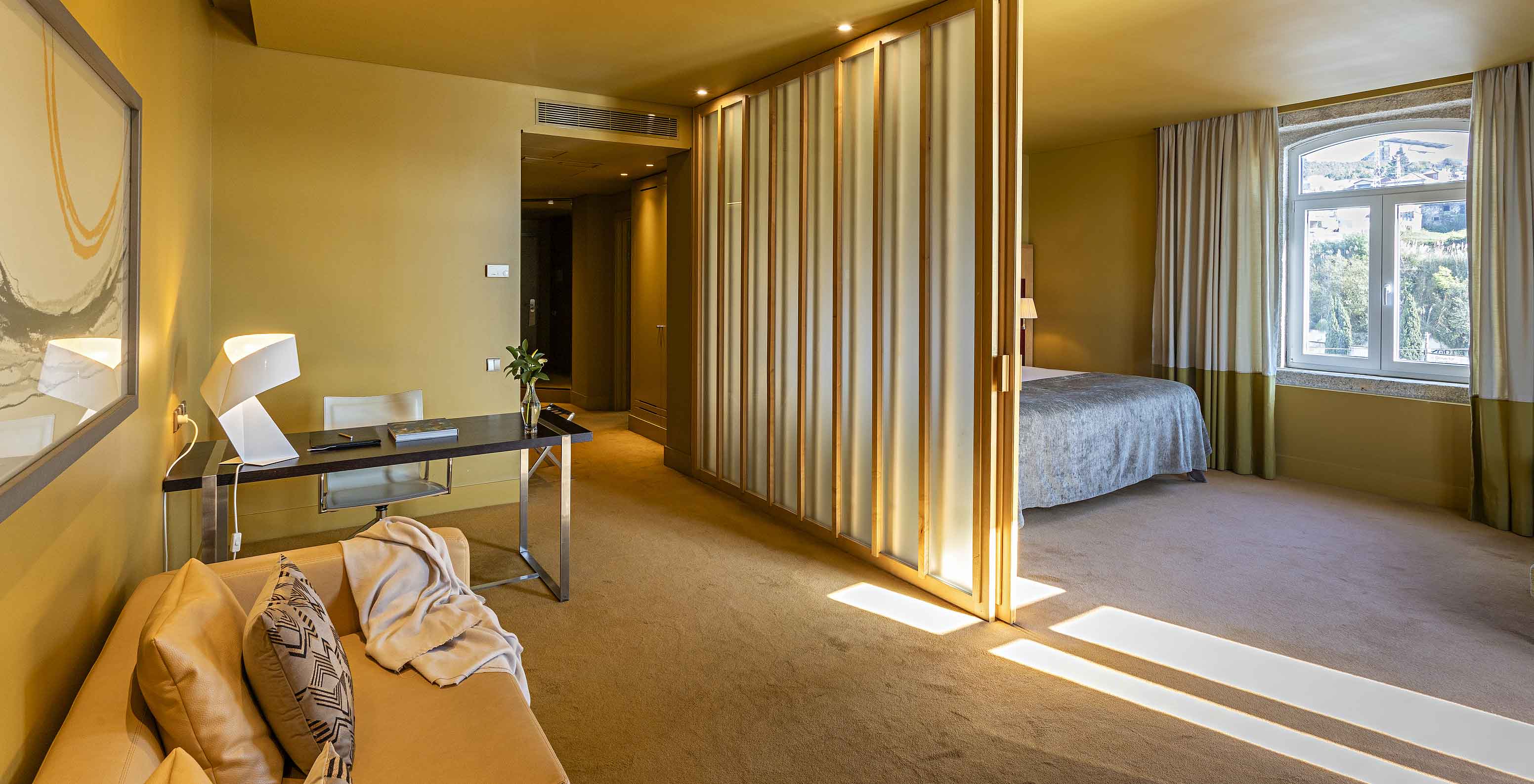 Die Standard Suite verfügt über ein Doppelbett mit Abtrennung zum Wohnzimmer mit sofa und Schreibtisch