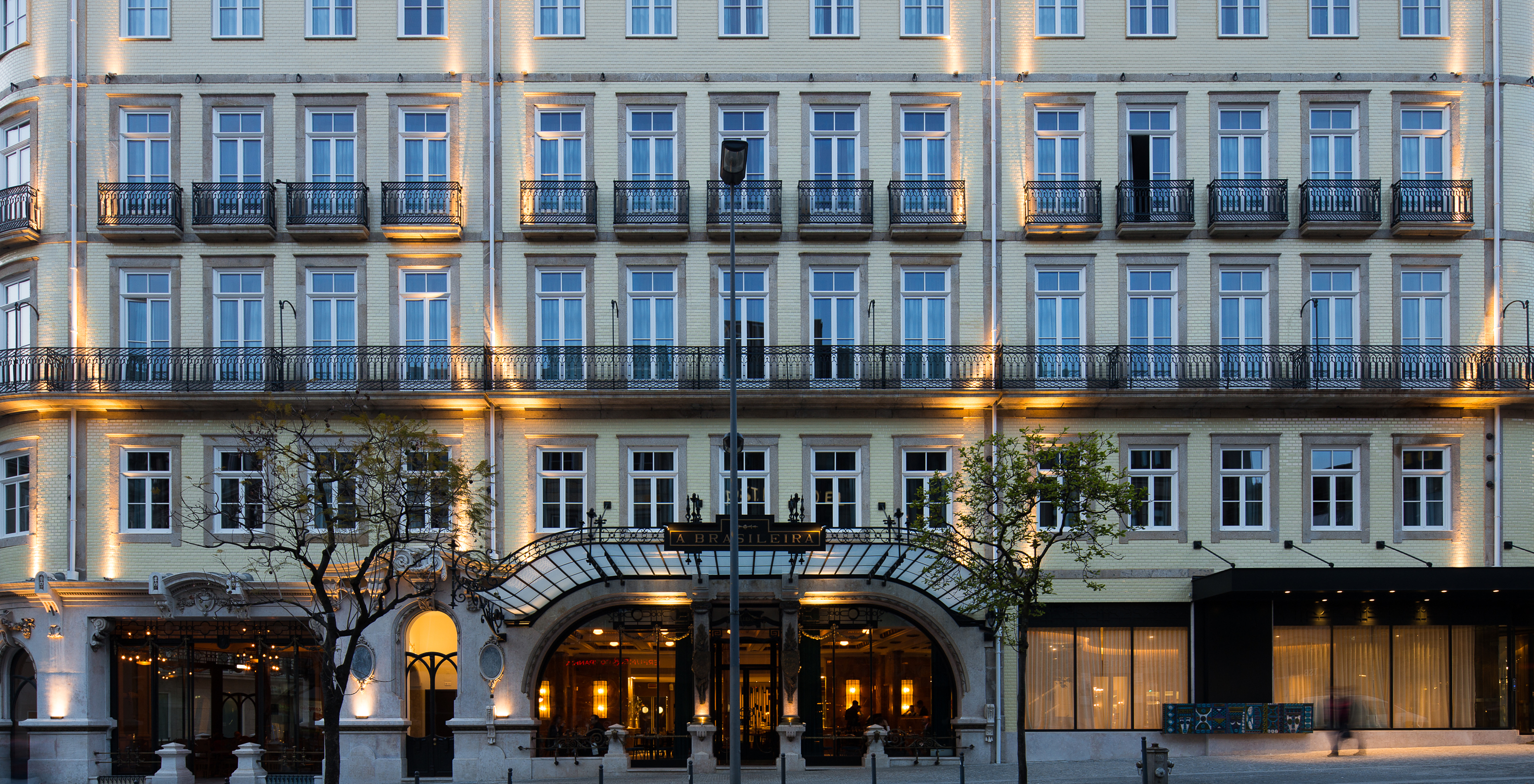 Die beleuchtete Fassade des Hotels Pestana Porto - A Brasileira zeigt beeindruckende Architektur mit klassischen Details