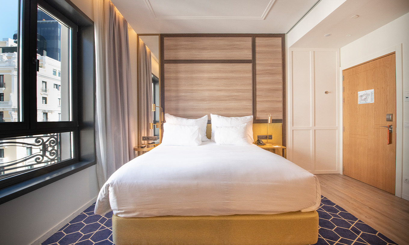 Der Premium mit Aussicht im Pestana CR7 Gran Vía Madrid hat ein Doppelbett und ein großes Fenster mit Blick auf die Gebäude