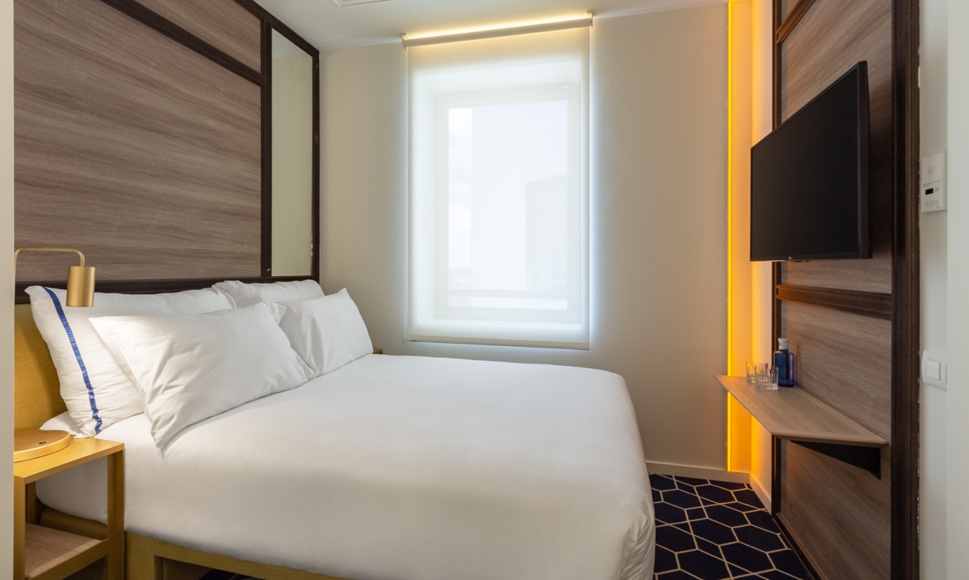 Das Kleine Doppelzimmer im Pestana CR7 Gran Vía Madrid hat ein Doppelbett, ein Fenster und einen gelben Nachttisch