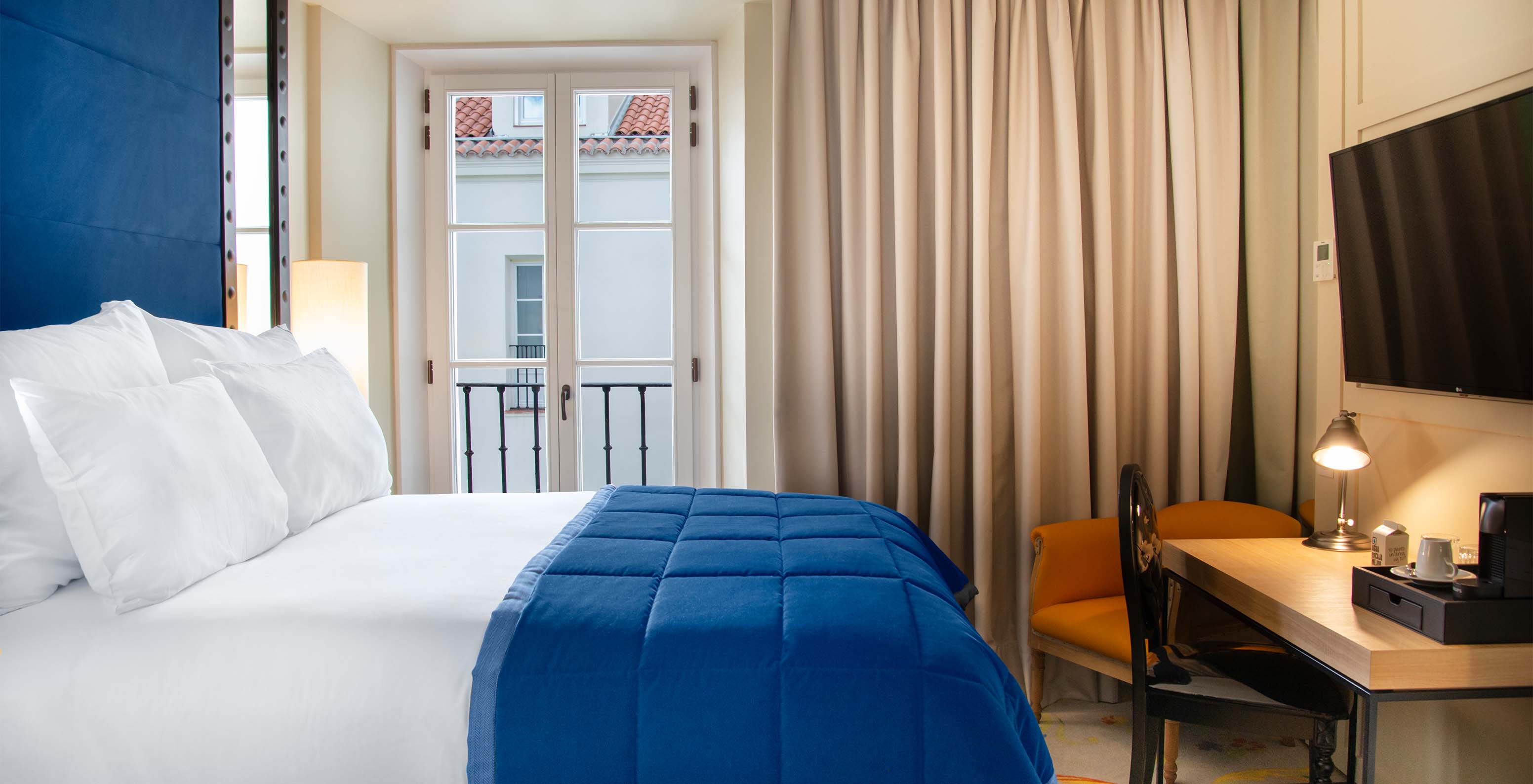 Das Klassische Zimmer im Pestana Collection Plaza Mayor hat ein Doppelbett, Fernseher, Schreibtisch und ein Fenster