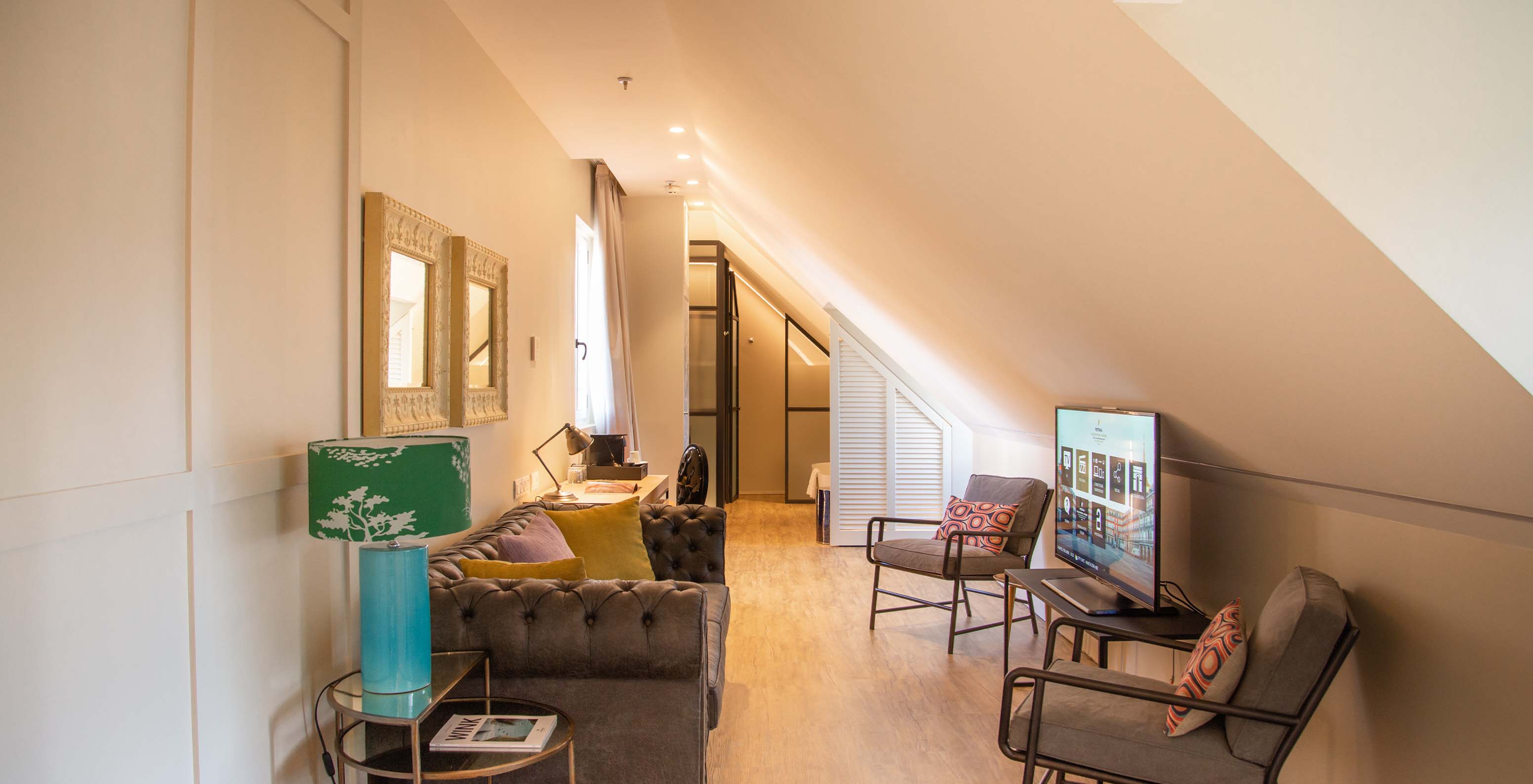 Die Suite Plaza Mayor hat ein Wohnzimmer mit Sofa, Stühlen, TV und Bildern 