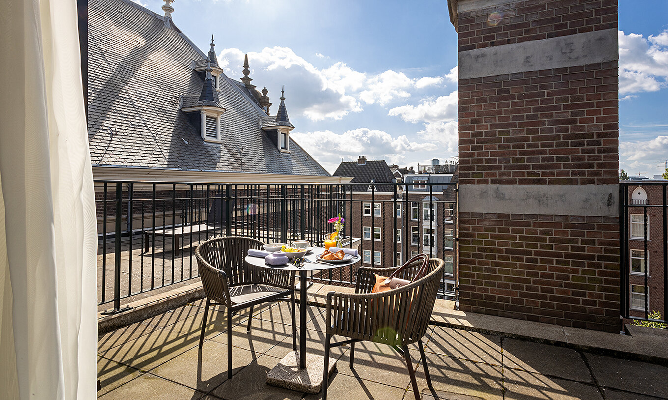 Das Executive Terrace Zimmer im Pestana Amsterdam Riverside hat einen Balkon mit Tisch
