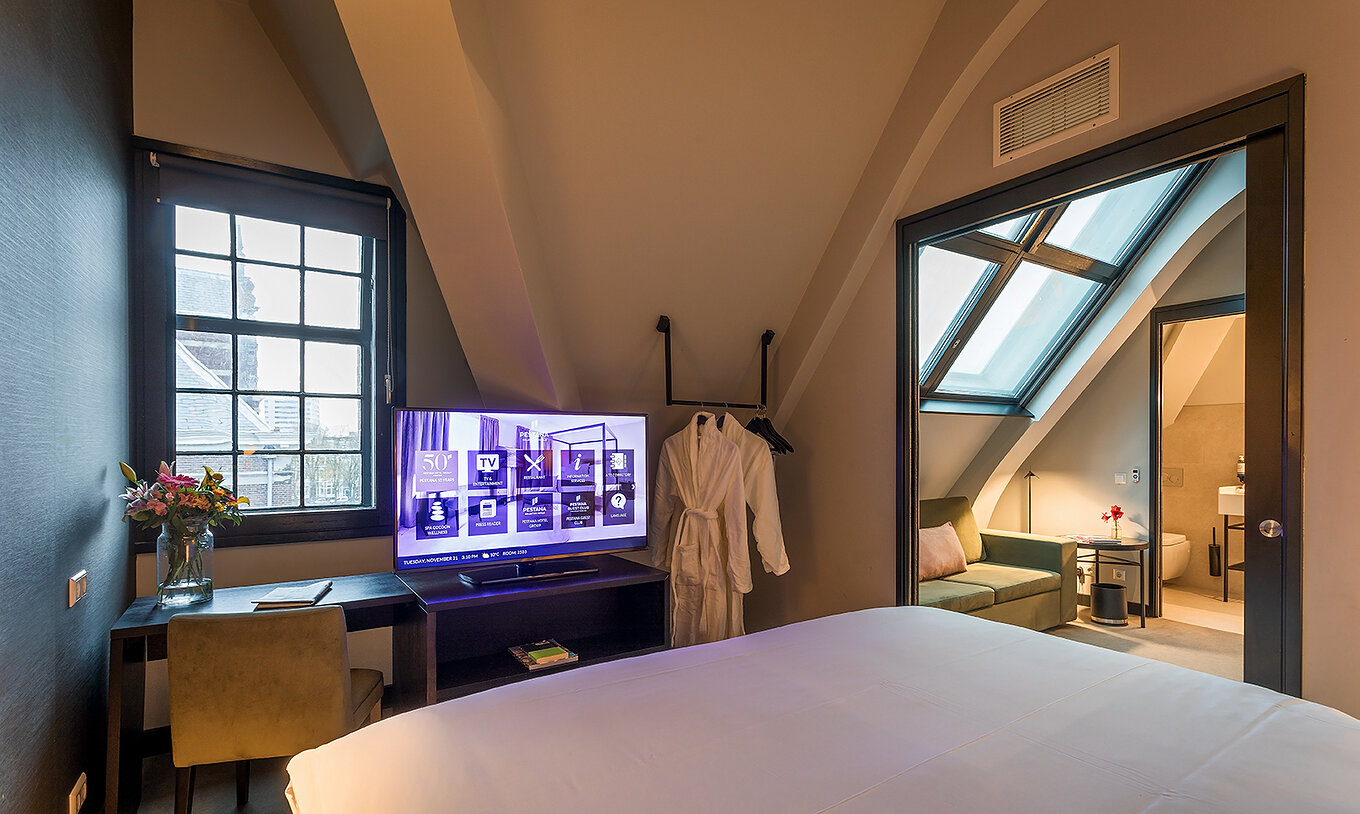 Das Loft Zimmer im Pestana Amsterdam Riverside hat ein grünes Sofa