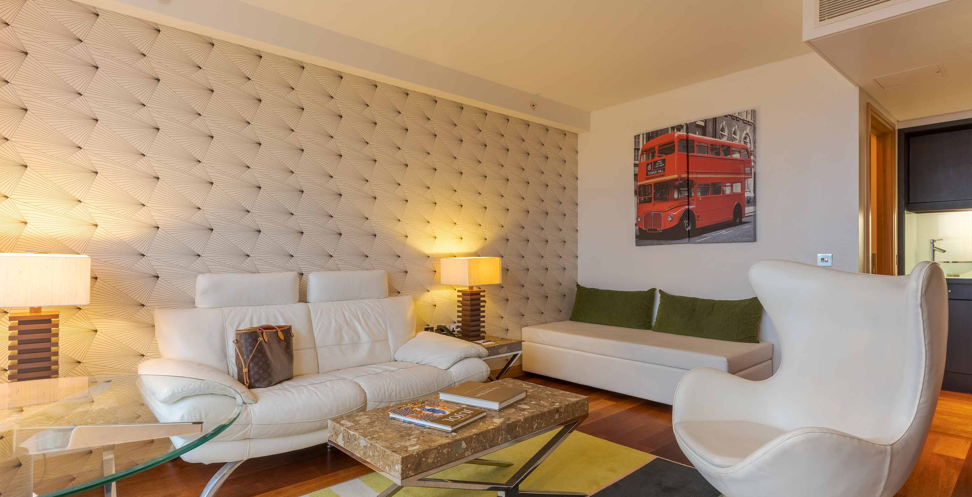 Die Executive One Bedroom Suite im Pestana Chelsea Bridge hat Sofa, Hocker, Couchtisch, Glastisch und Sessel