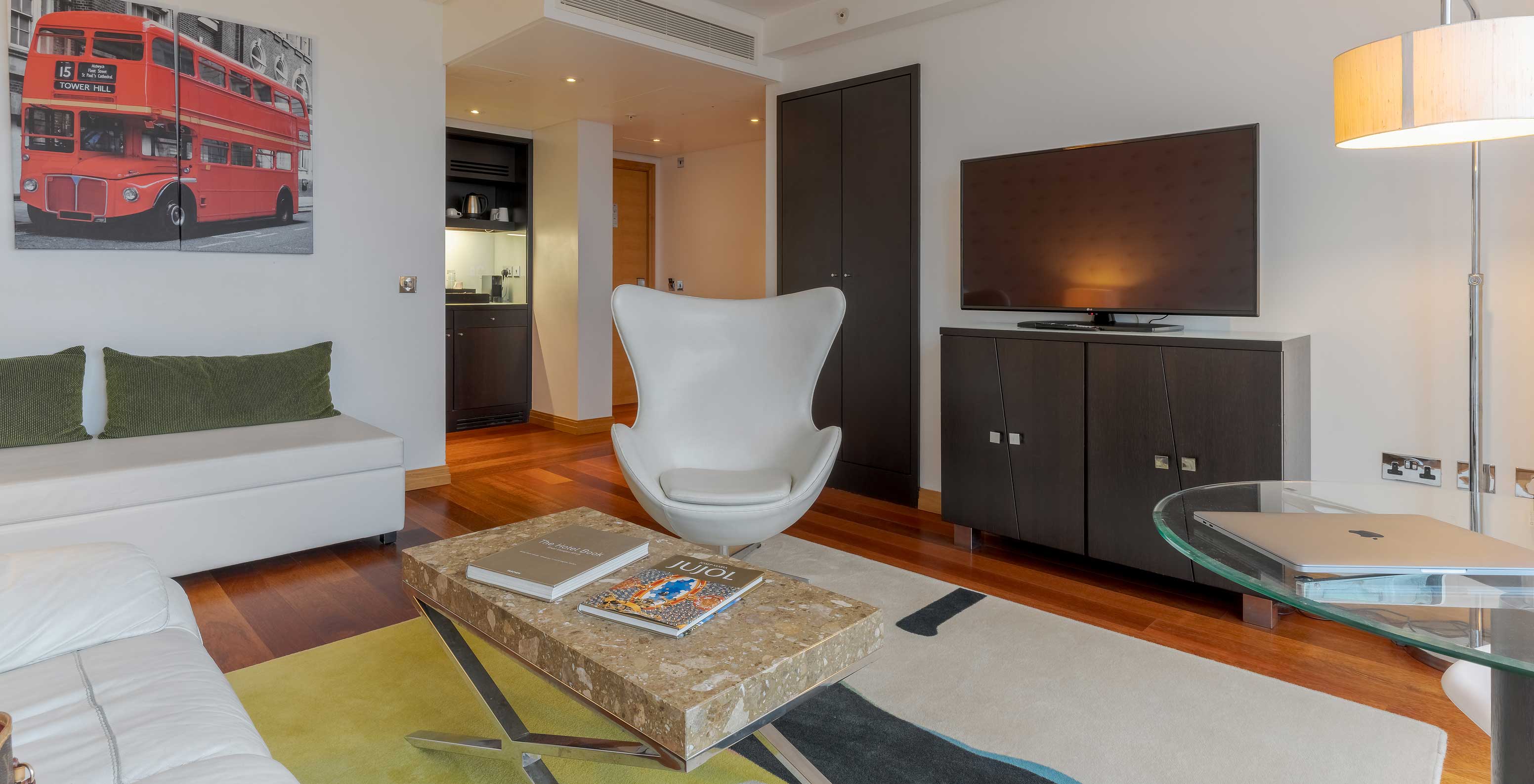 Die Executive One Bedroom Suite im Pestana Chelsea Bridge hat Wohnzimmer mit Sofa, Couchtisch, Sessel und TV