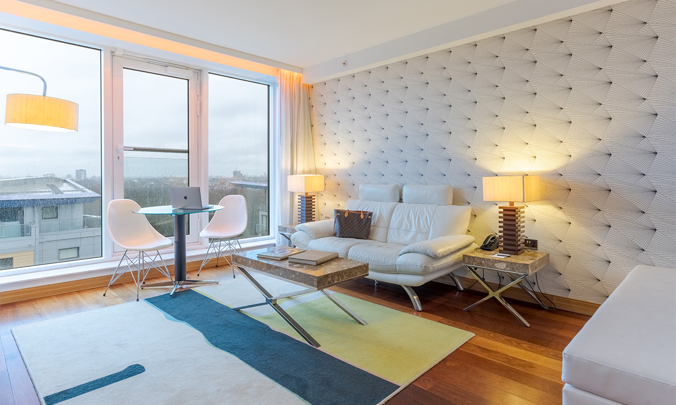 Die Executive Suite mit 1 Schlafzimmer im Pestana Chelsea Bridge hat ein Sofa mit Couchtisch, Tisch mit Stühlen und Fenster