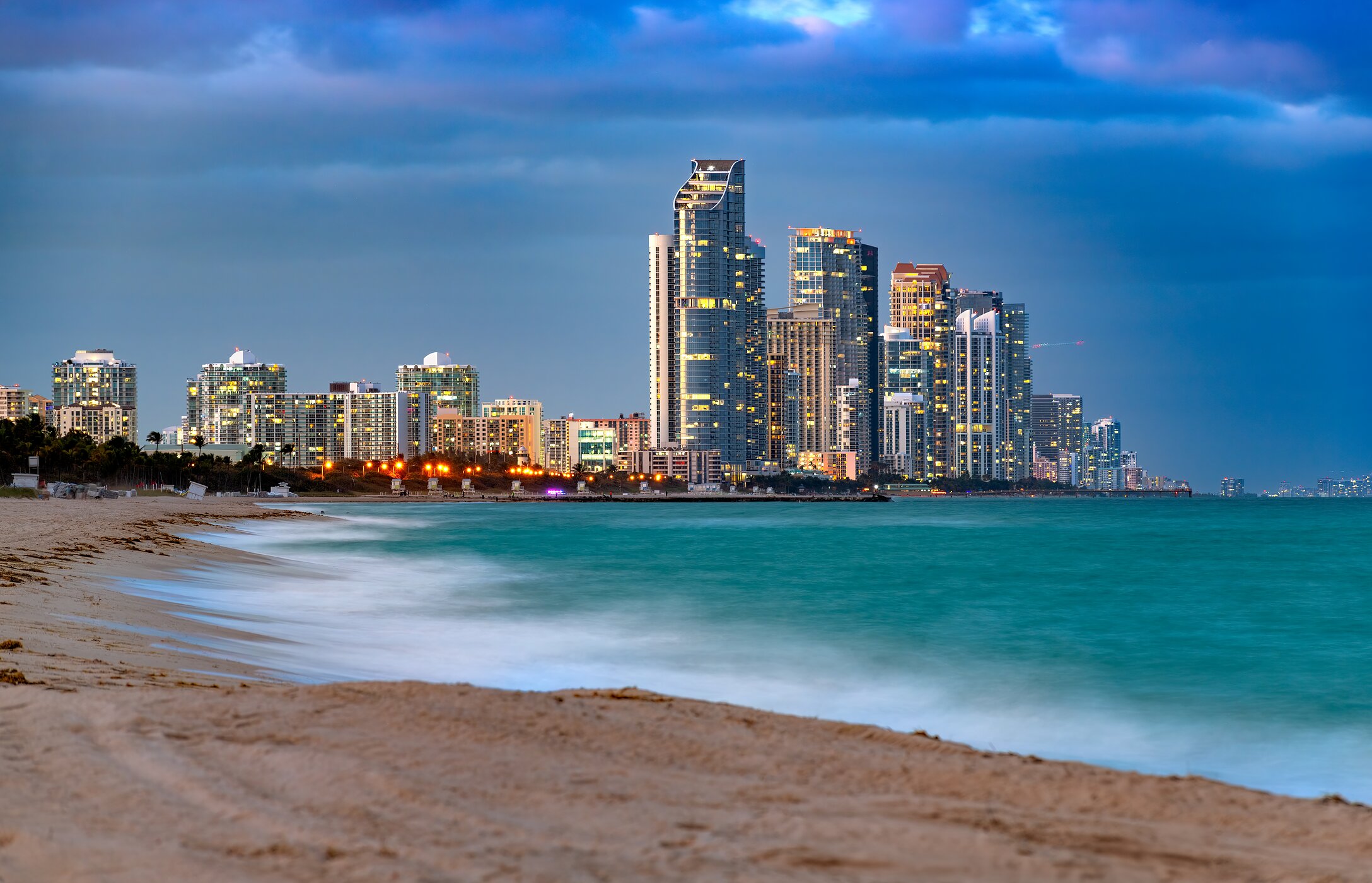 Sunny Isles Beach in Miami mit kristallklarem Wasser, weißem Sand und modernen Gebäuden im Hintergrund