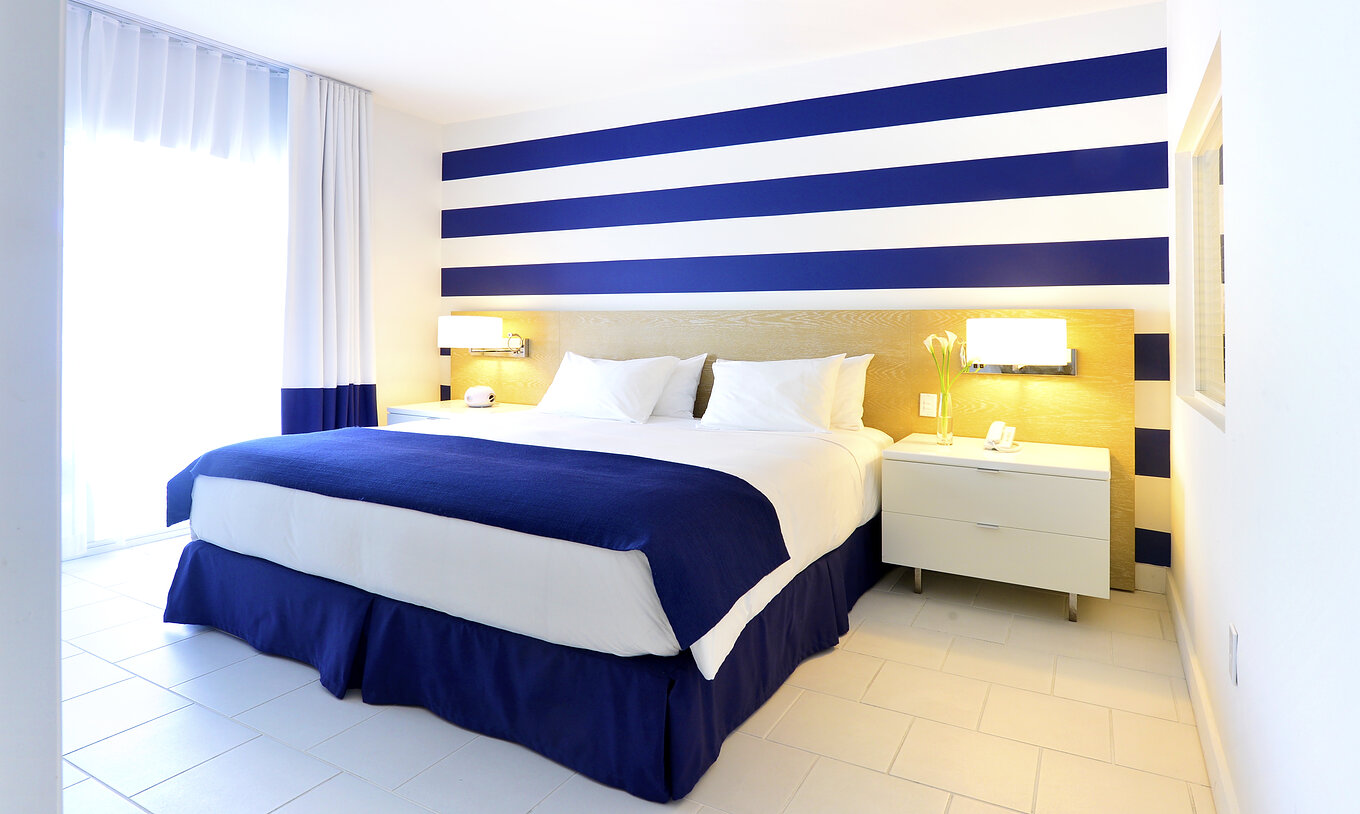 Die Suite King mit Balkon im Pestana Miami South Beach hat Doppelbett, Nachttisch und Lampe