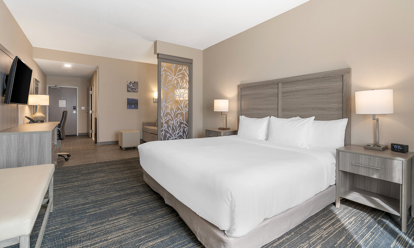 Die ADA King-Suite im Pestana Orlando Suites Lake Buena Vista hat ein Doppelbett, Nachttisch und Fernseher