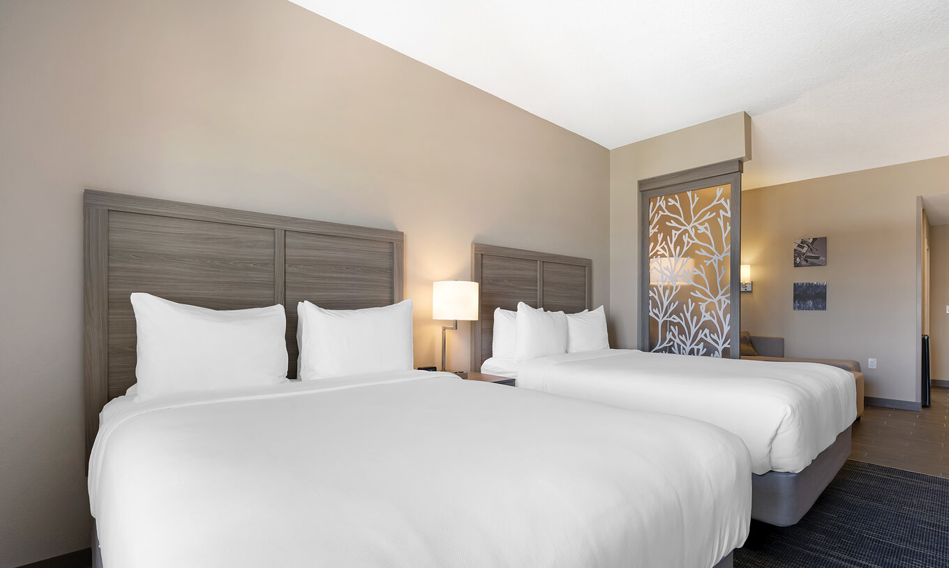 Die Queen Duplex-Suite im Pestana Orlando Suites Lake Buena Vista hat zwei Doppelbetten und Nachttisch mit Lampe