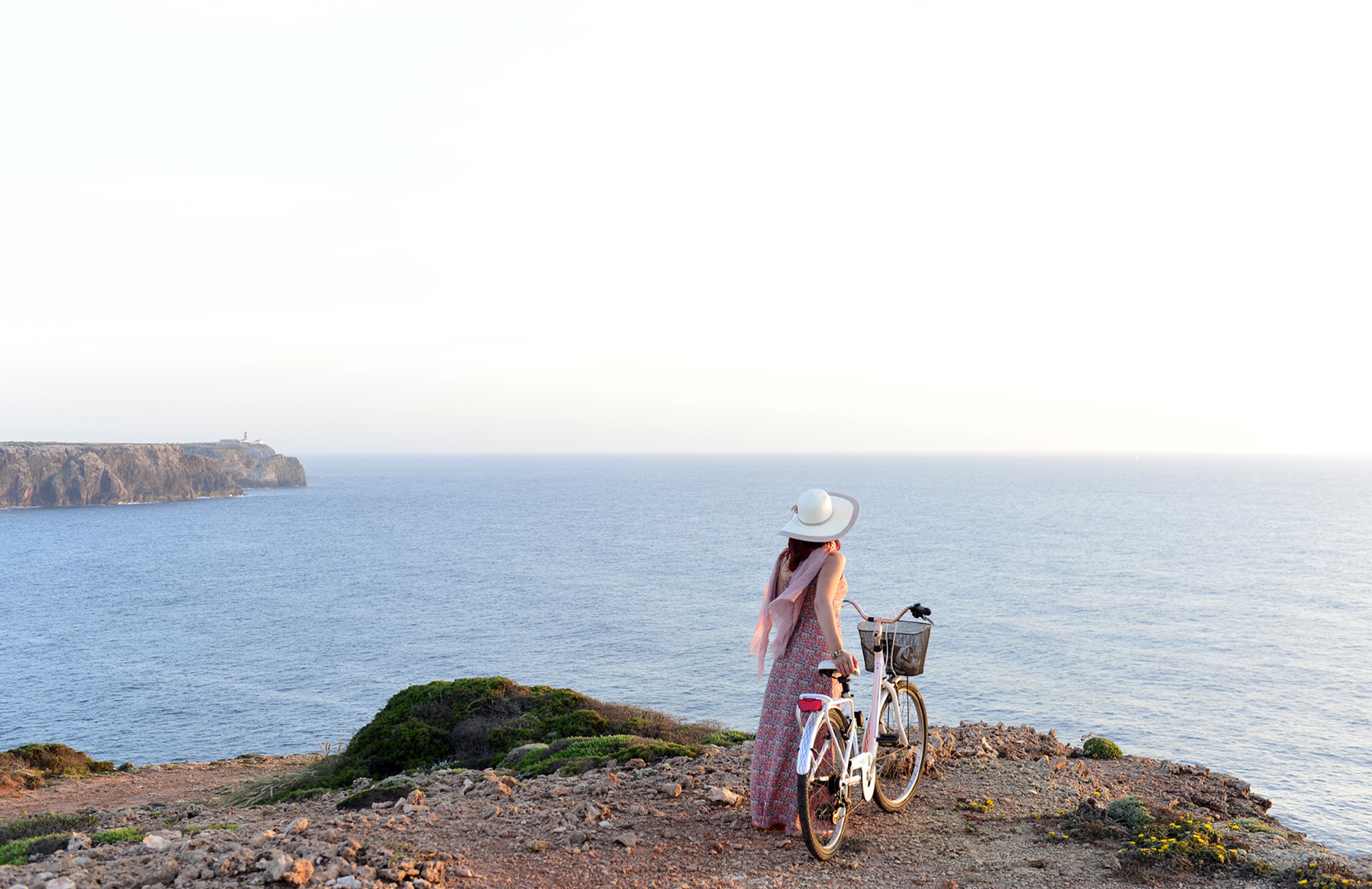 Frau geht mit einem Fahrrad entlang der Klippen an der portugiesischen Küste, bereitgestellt von Pousadas de Portugal