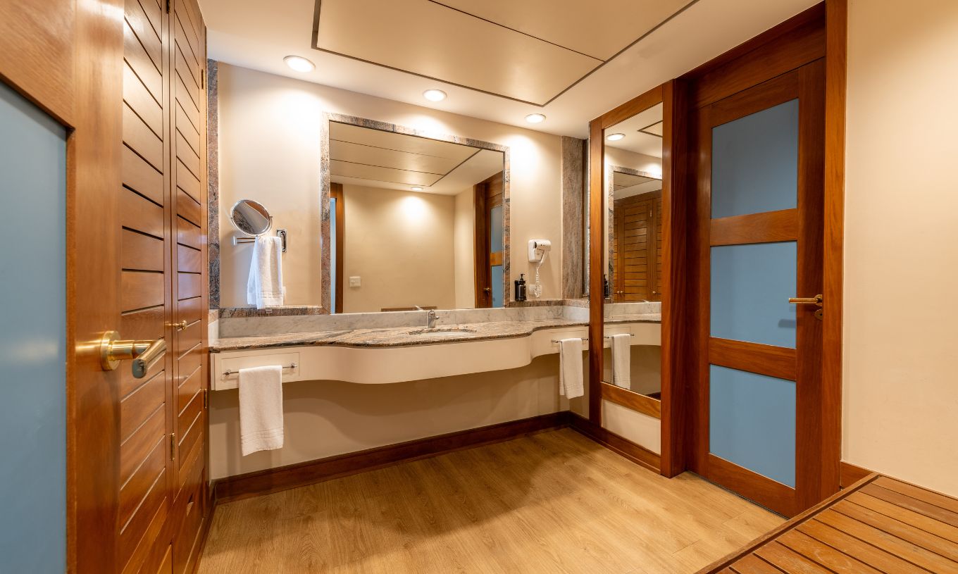 The Family Room at Pestana São Paulo has a bathroom with a large sink with a mirror, a hairdryer, and towels
