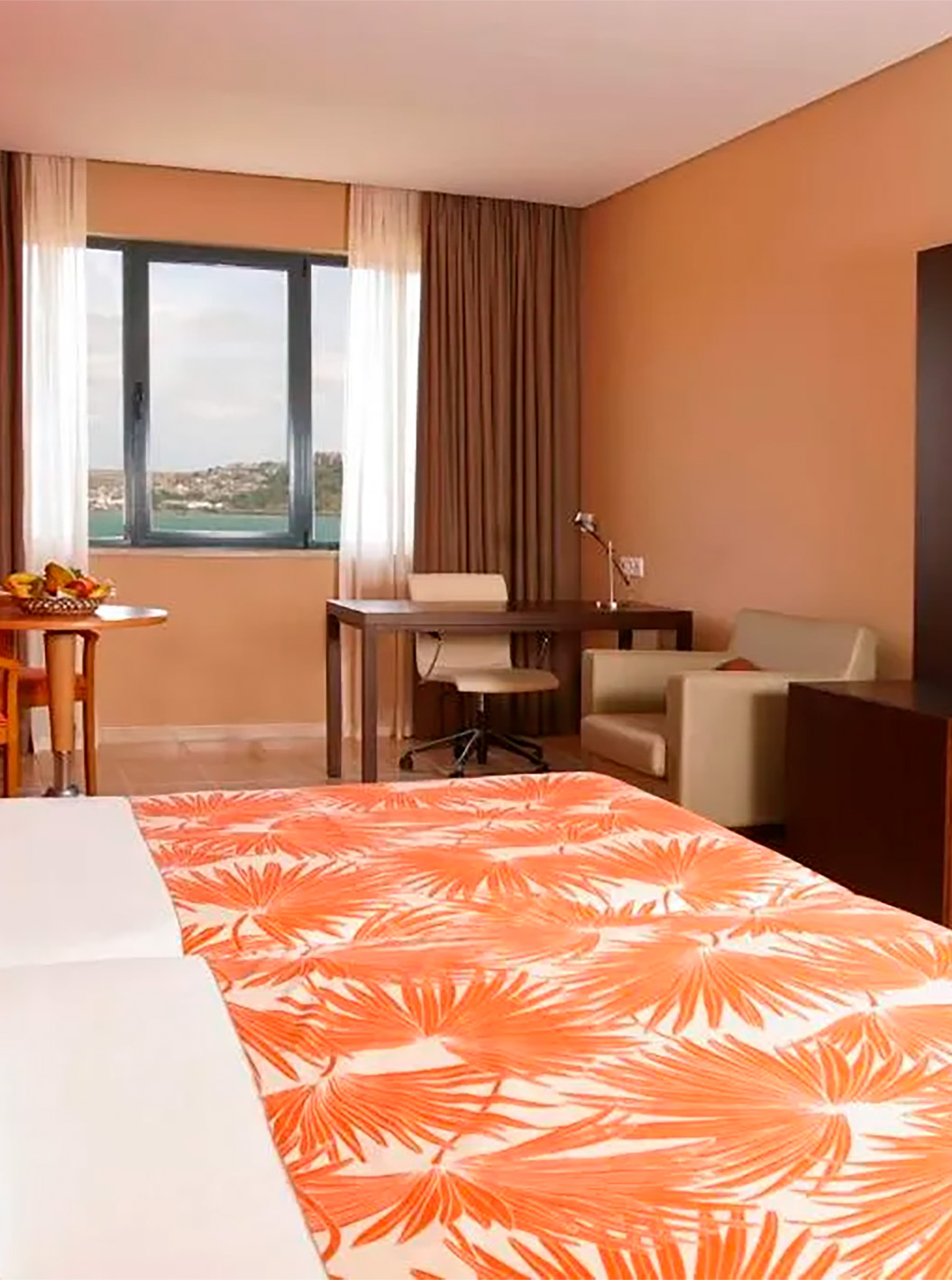 The Premium Suite at Pestana Tropico features two single beds, desk with chair, a table, and sea view