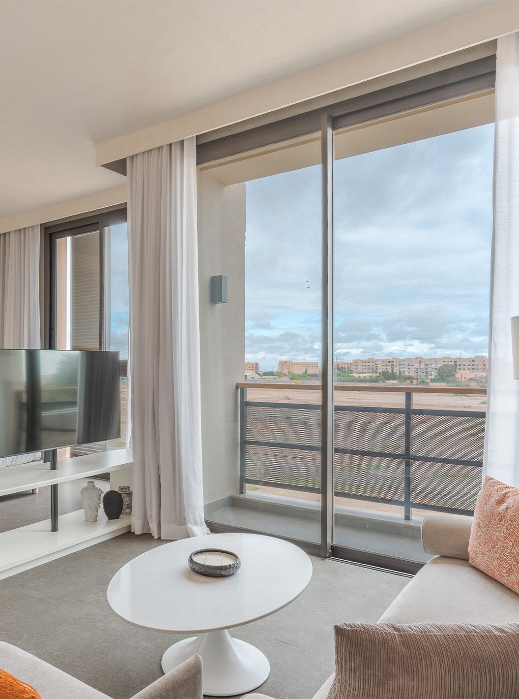 The CR7 Junior Suite at Pestana CR7 Marrakech has a balcony and a seating area inside the room, with sofas and a TV