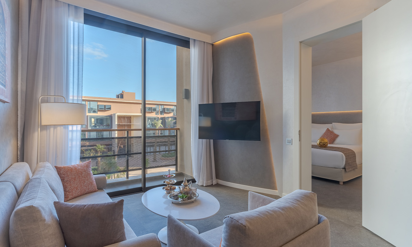 The CR7 Suite Avenue at Pestana CR7 Marrakech has a living room with sofas and TV, and a balcony overlooking M Avenue