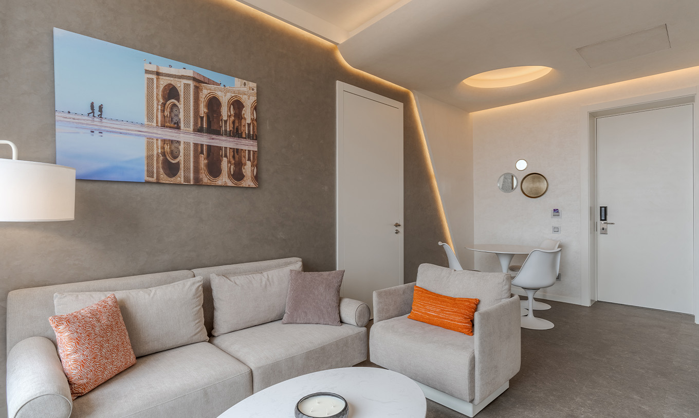 The CR7 Suite at Pestana CR7 Marrakech has a living room with two sofas, a painting, and a dining table