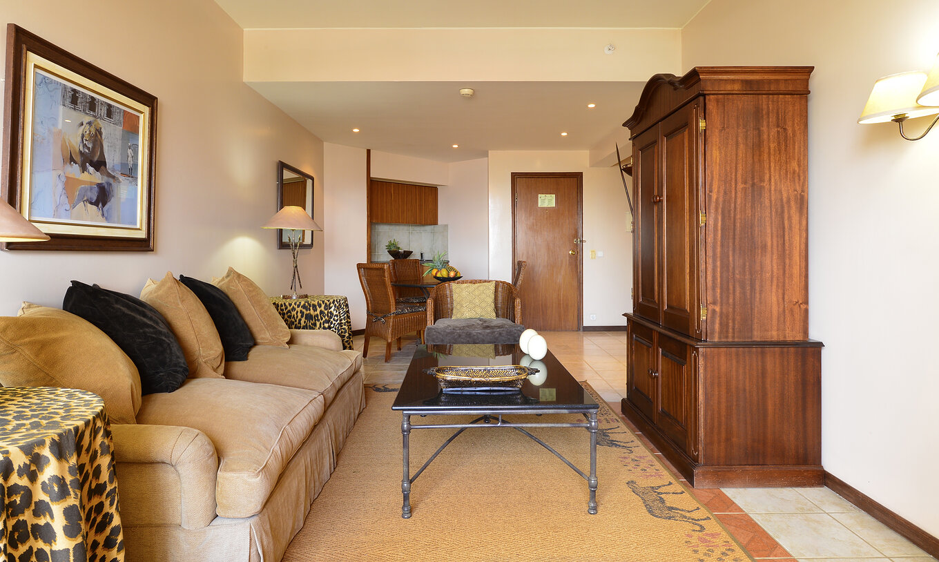 The Luxury Suite of Pestana Rovuma has a living room with a beige white sofa and two tables with leopard-patterned covers