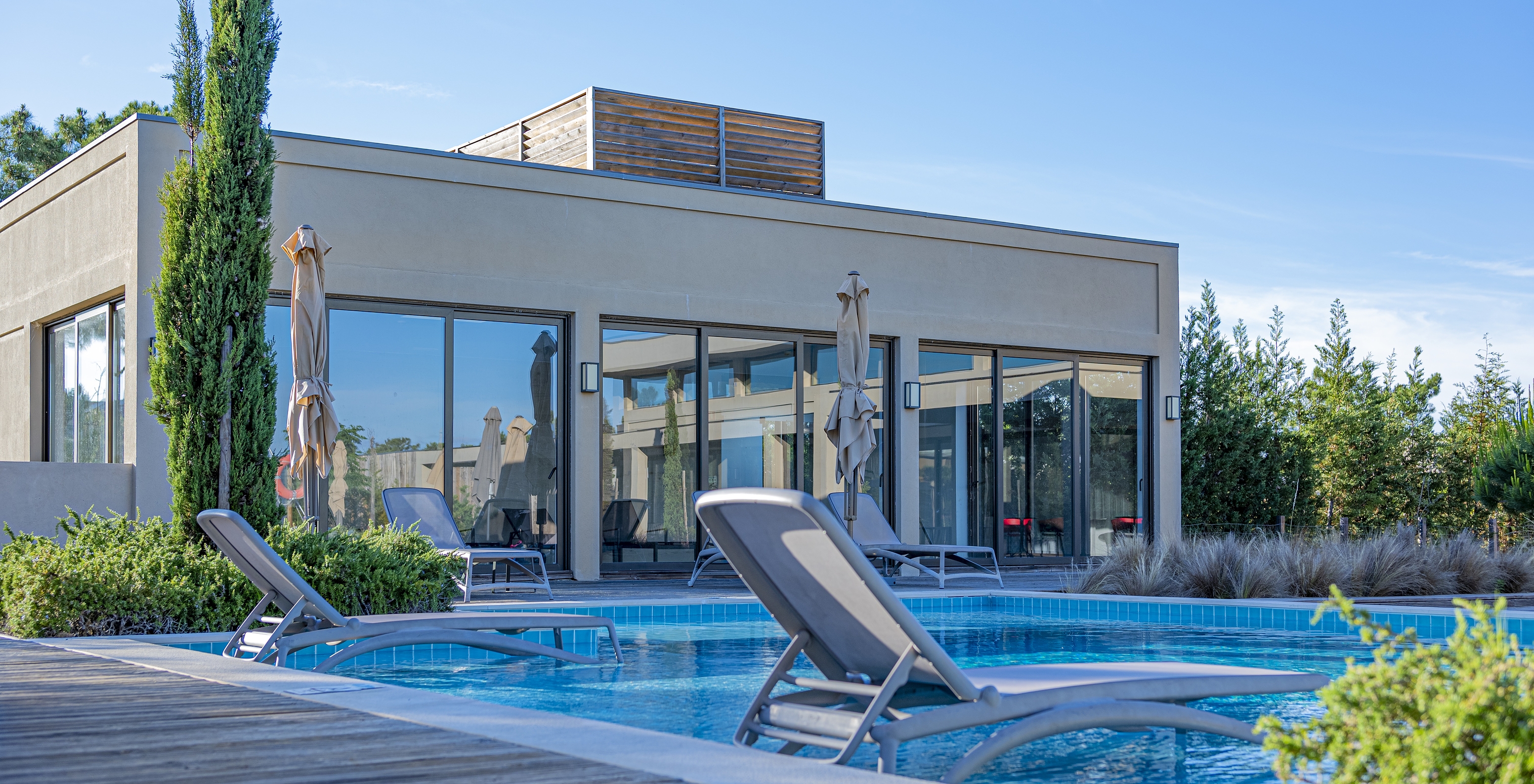 Outdoor pool at Pestana Tróia Eco Resort with two sun loungers in the water, where you can relax