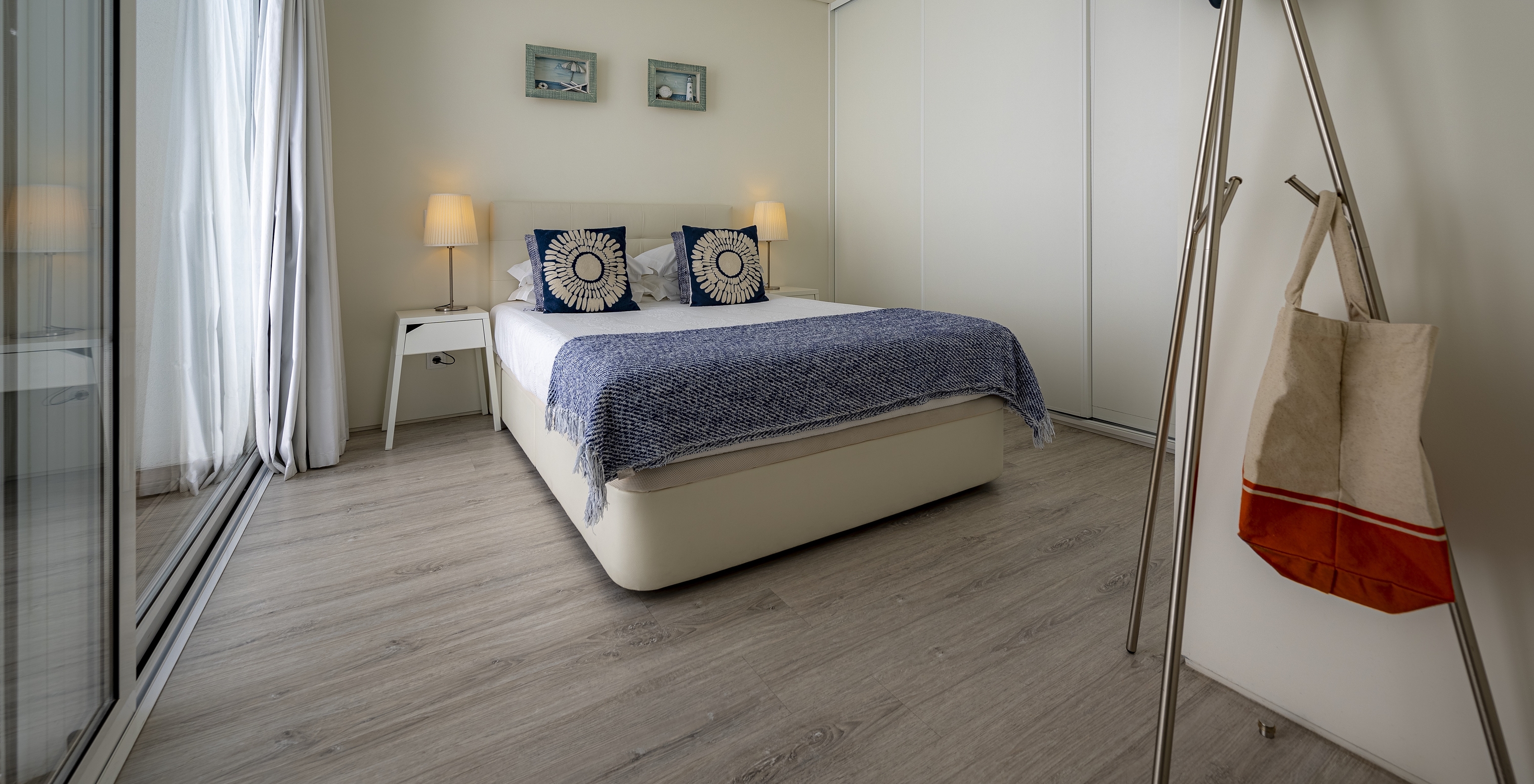 The Green Villa of Pestana Tróia Eco Resort has a double bed with two bedside tables and a blue bedspread