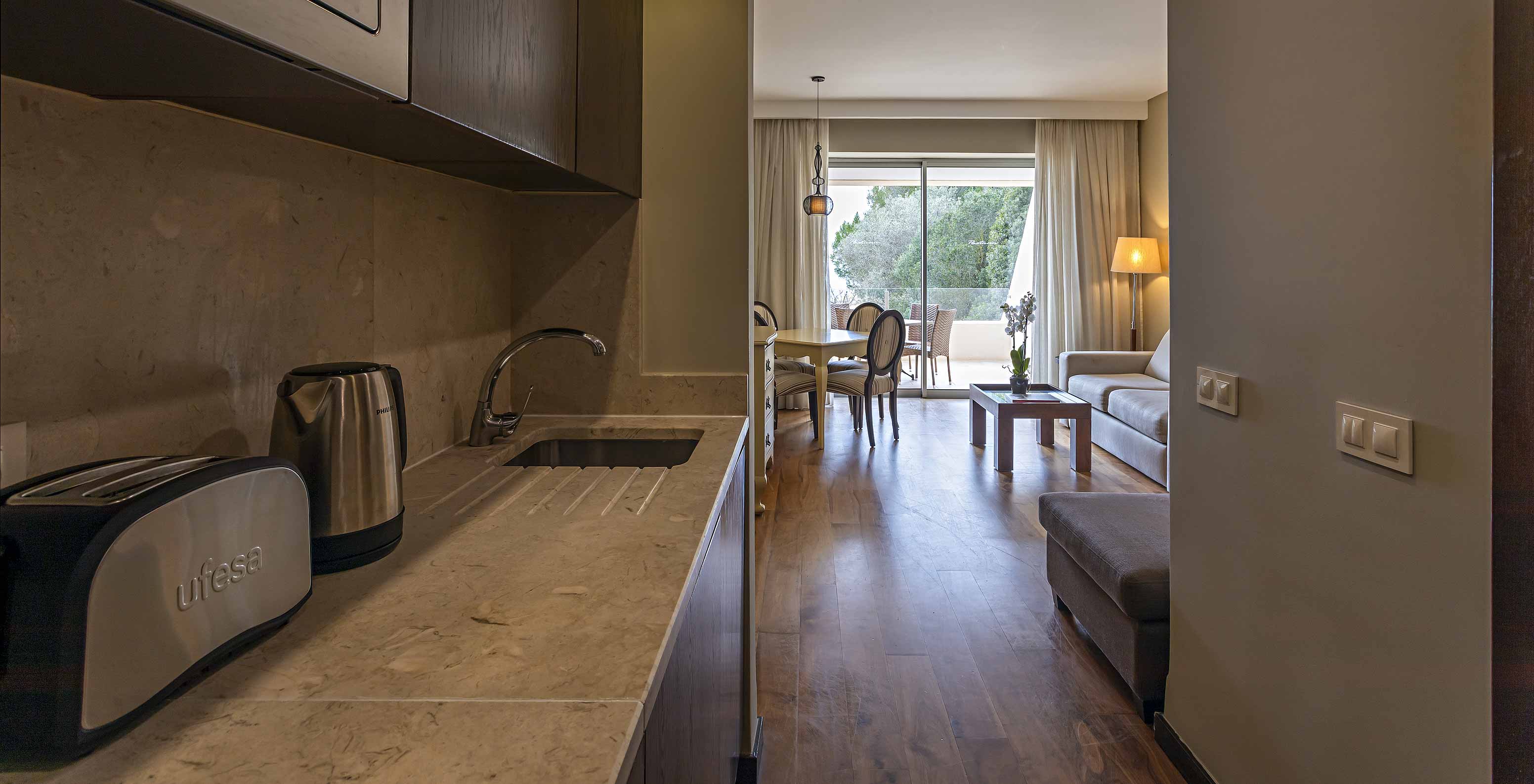 The Cliff Suite T1 at Pestana Alvor Praia has a kitchen with access to the living room, a kettle, a toaster, and a microwave