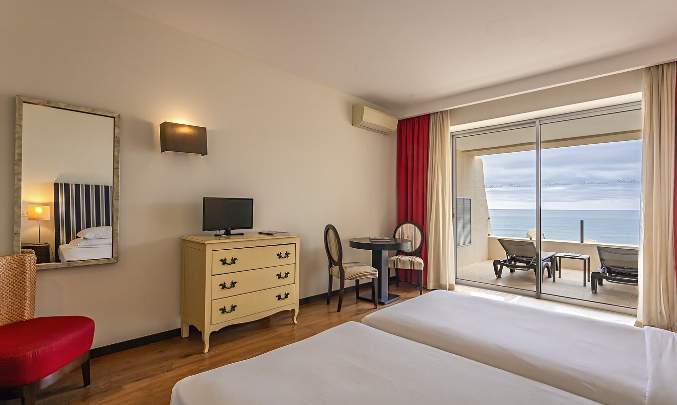 The Cliff Studio at Pestana Alvor Praia has a double bedroom with a dresser, a television, and a balcony with a sea view