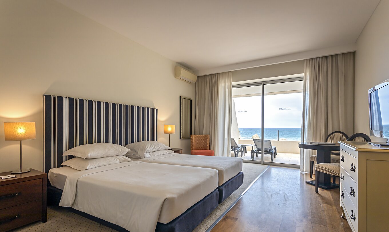 The Cliff Suite T1 at Pestana Alvor Praia has a double bedroom with a balcony with sun loungers and a sea view