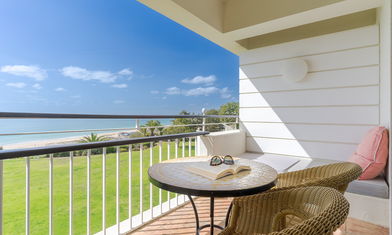 The Sea View Deluxe at Pestana Alvor Praia has a balcony with chairs, a table, and a sofa with sea views