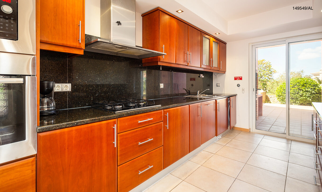 The Pestana Carvoeiro Golf T2 Superior Apartment has a kitchen with wooden cabinets and appliances