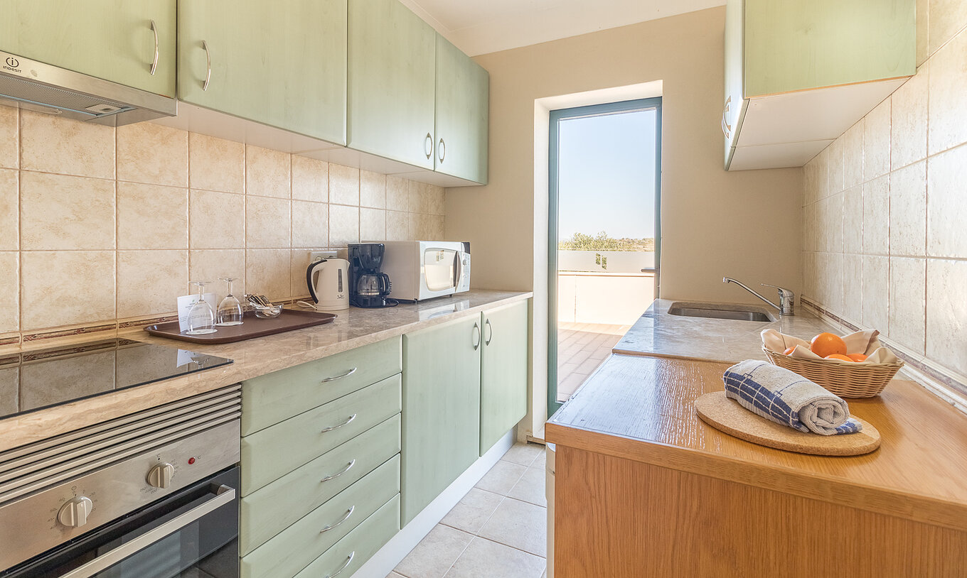 The studio at Pestana Gramacho Residences has a modern kitchen with appliances and access to the balcony