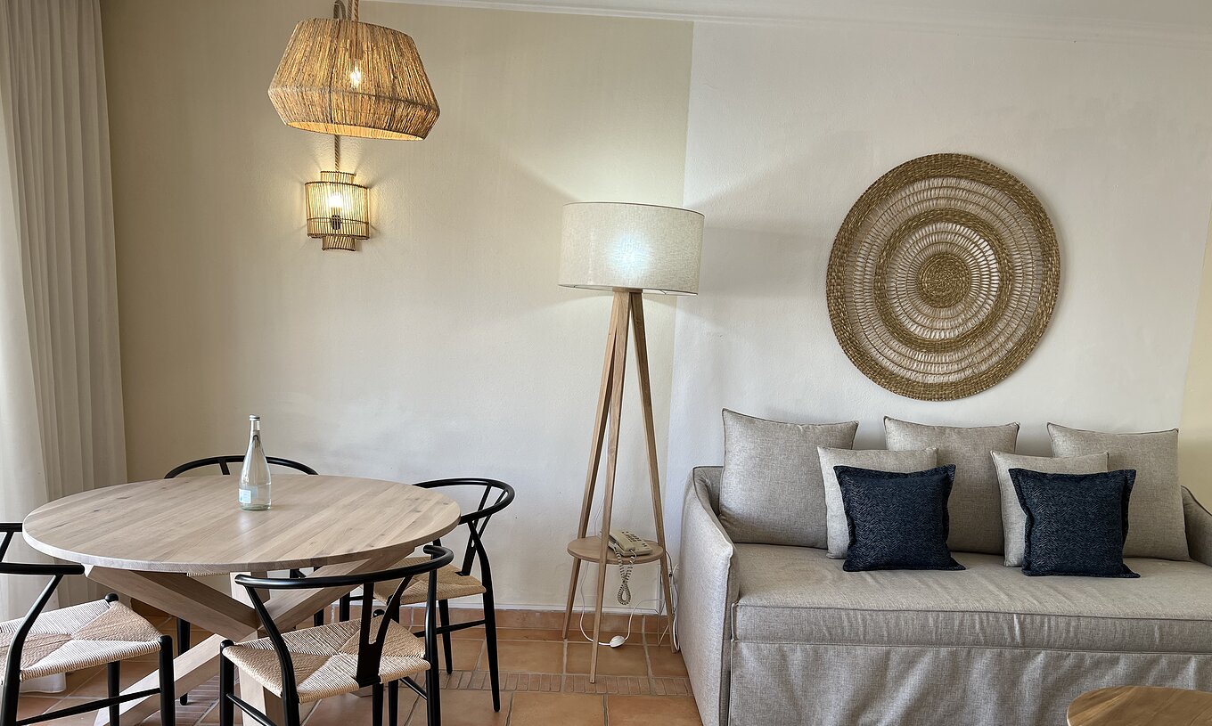 The T1 Apartment Standard do Pestana Palm Gardens has a living room with a sofa and cushions and a round table