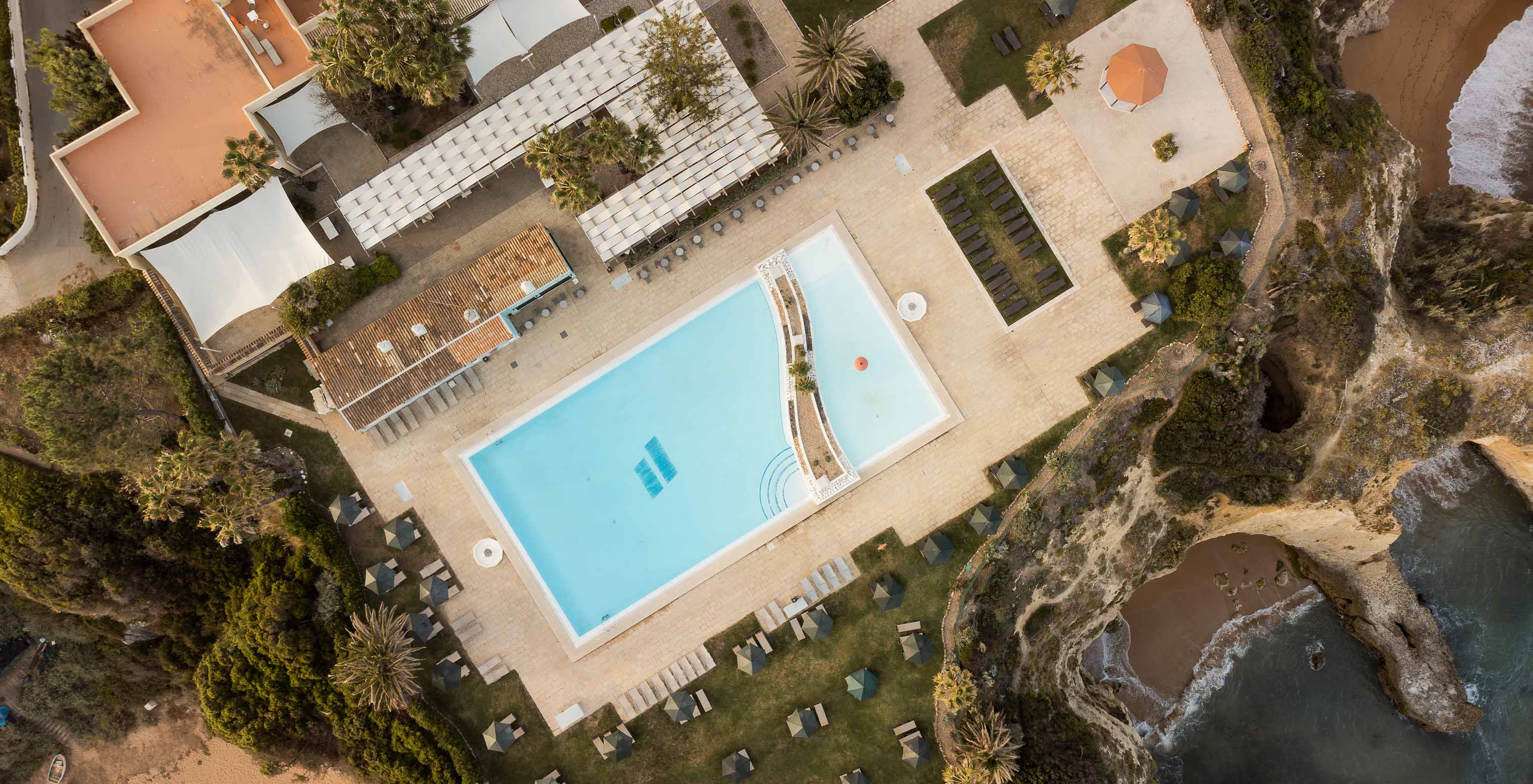 Drone view of Pestana Viking outdoor pool, with palm trees, sun loungers and sea view