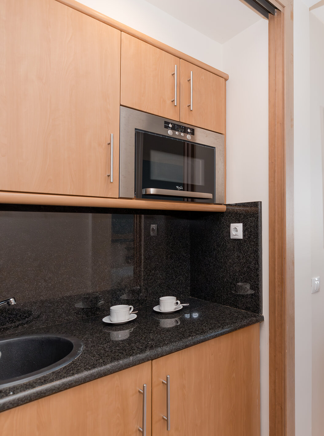 The Deluxe Garden View at Pestana Viking has a desk and a small kitchen with microwave and cabinets