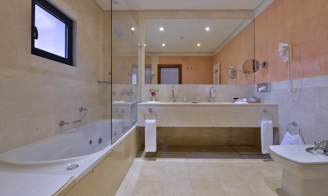 The Suite Garden View Vila Sol at Pestana Vila Sol - Vilamoura has a bathroom with two sinks and bathtub with shower