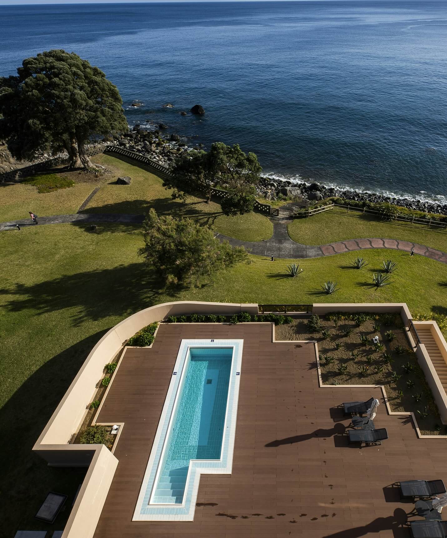 Pool at Pestana Bahia Praia on wooden deck with sea view and surrounding green area