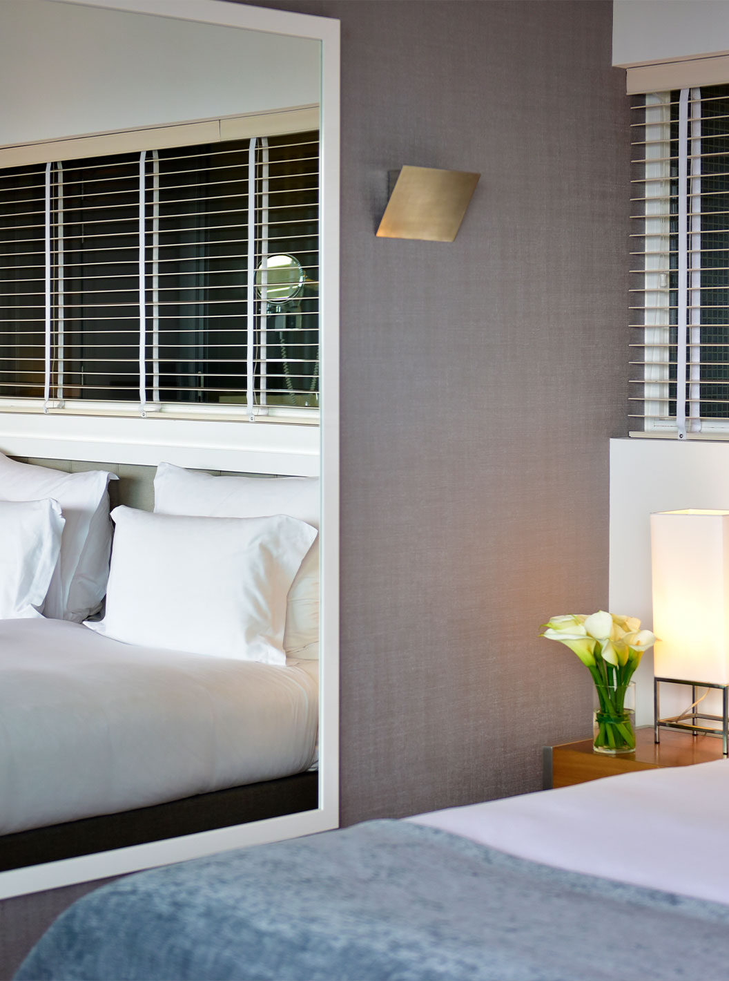 The Suite at Pestana Cidadela Cascais has a double bed, a bedside table, and a large mirror