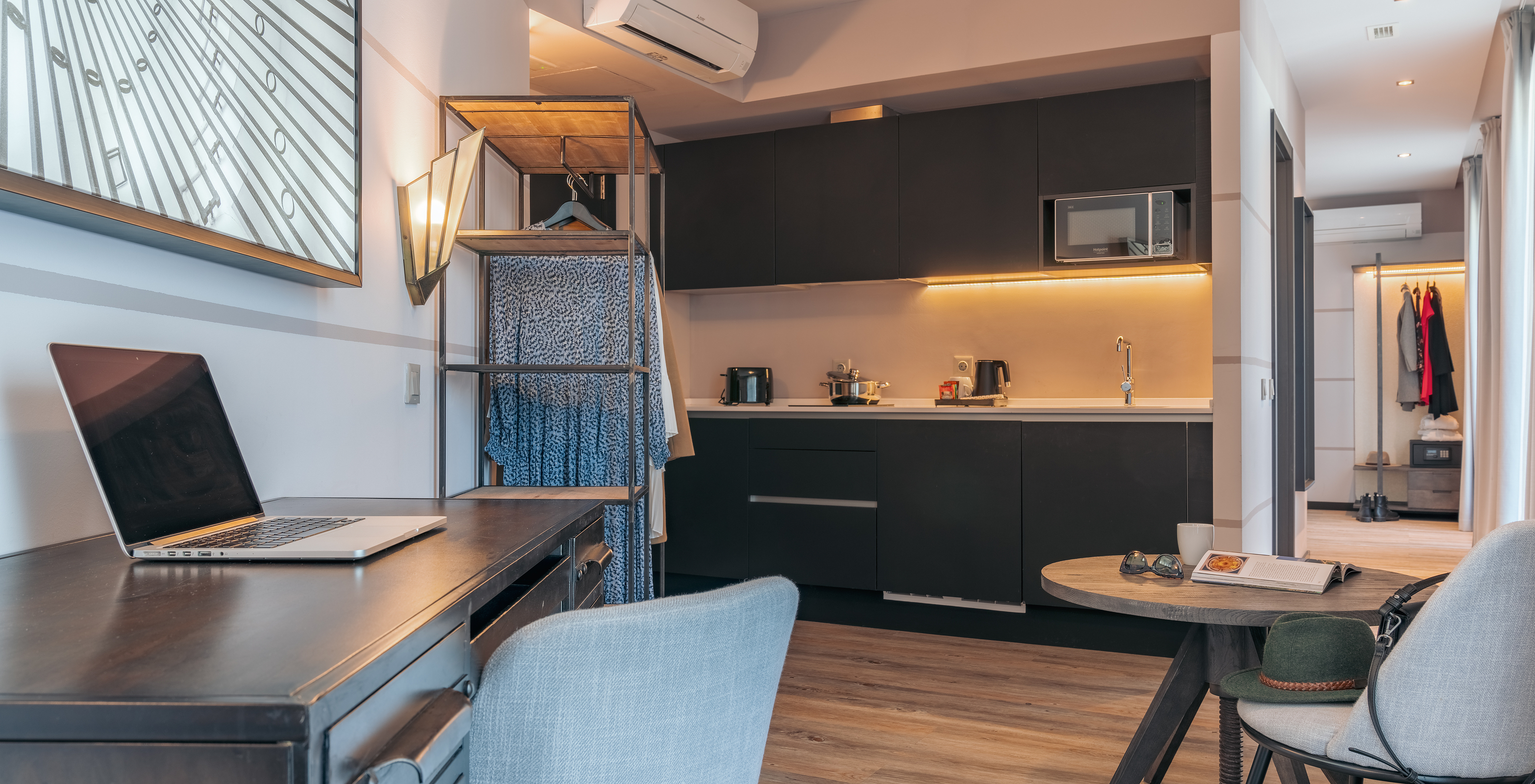 The Rooftop Junior Suite at Pestana Lisboa Vintage has an equipped kitchen, a table, a desk and a wardrobe with clothes