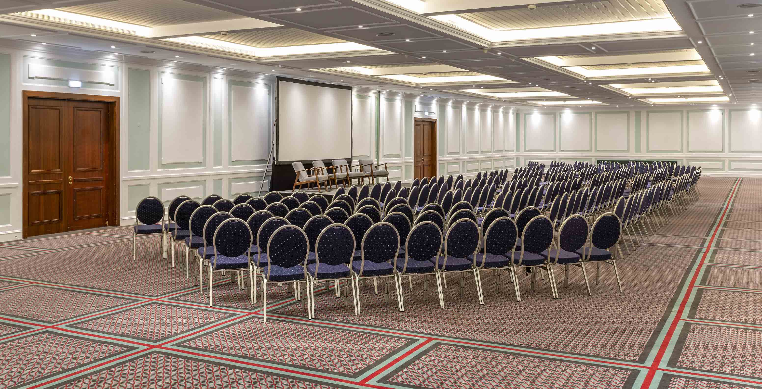 Pestana Palace Lisboa has a large meeting and event room with a carpeted floor and blue chairs
