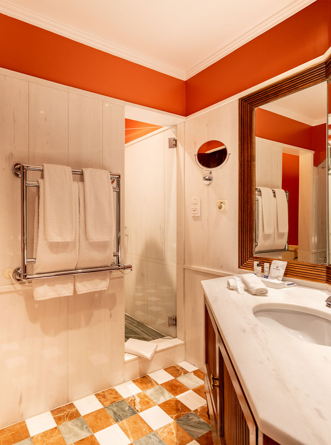 The Suite Collection at Pestana Palace Lisbon features a white marble bathroom with a bathtub, shower, toilet, and towels