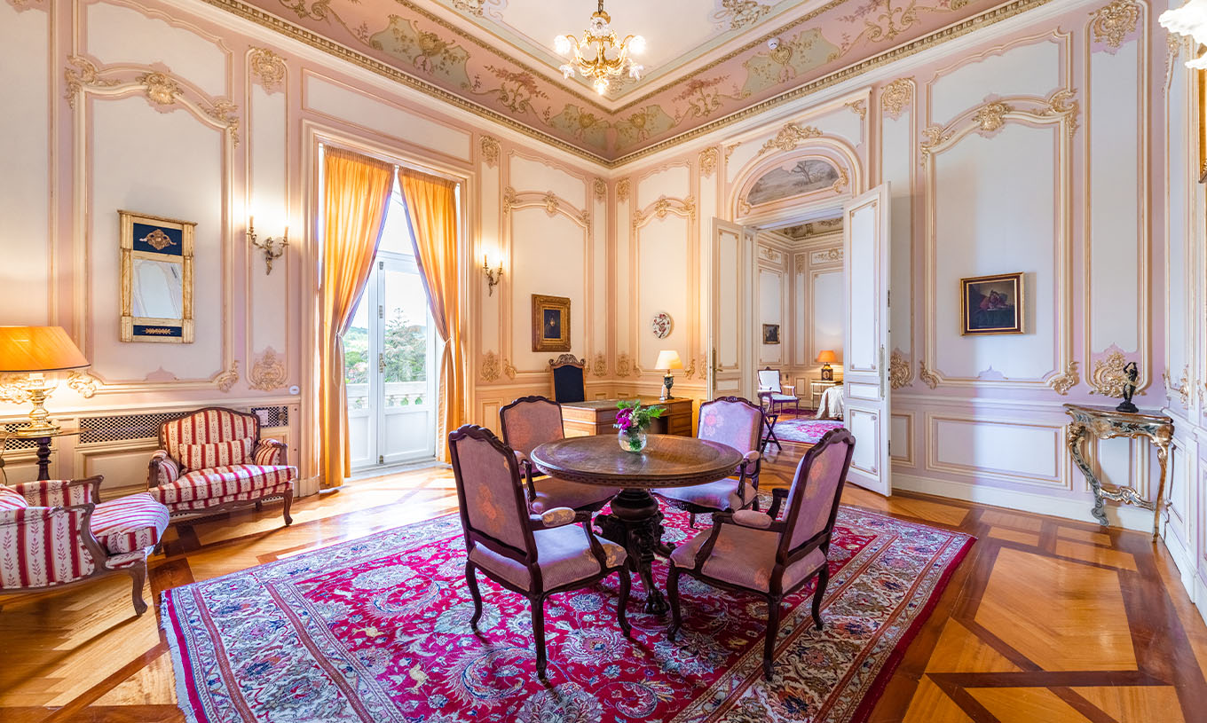 The Suite D. Carlos do Pestana Palace Lisboa has a large luxurious hall with one window and a dining table
