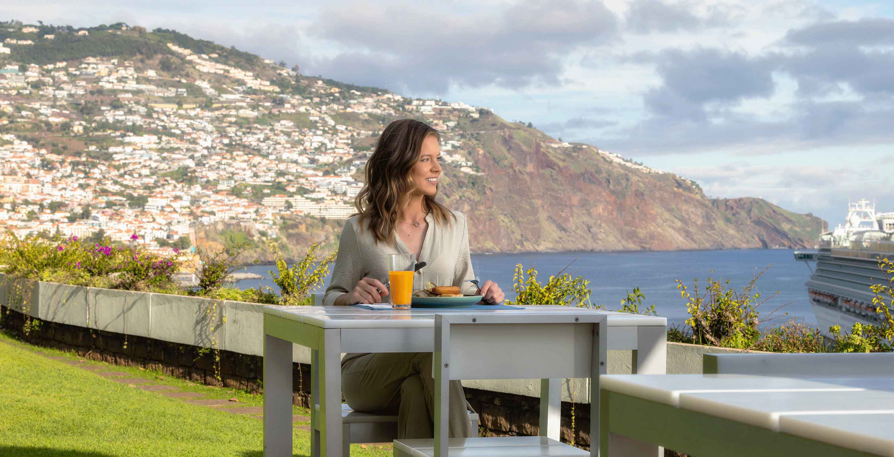 View from a terrace with a table and sun loungers overlooking the sea at the Pestana Casino Park