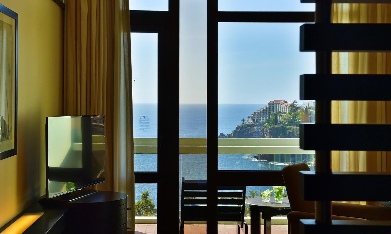 The Sea View Suite at Pestana Casino Park has a TV and a balcony with a table and sea view