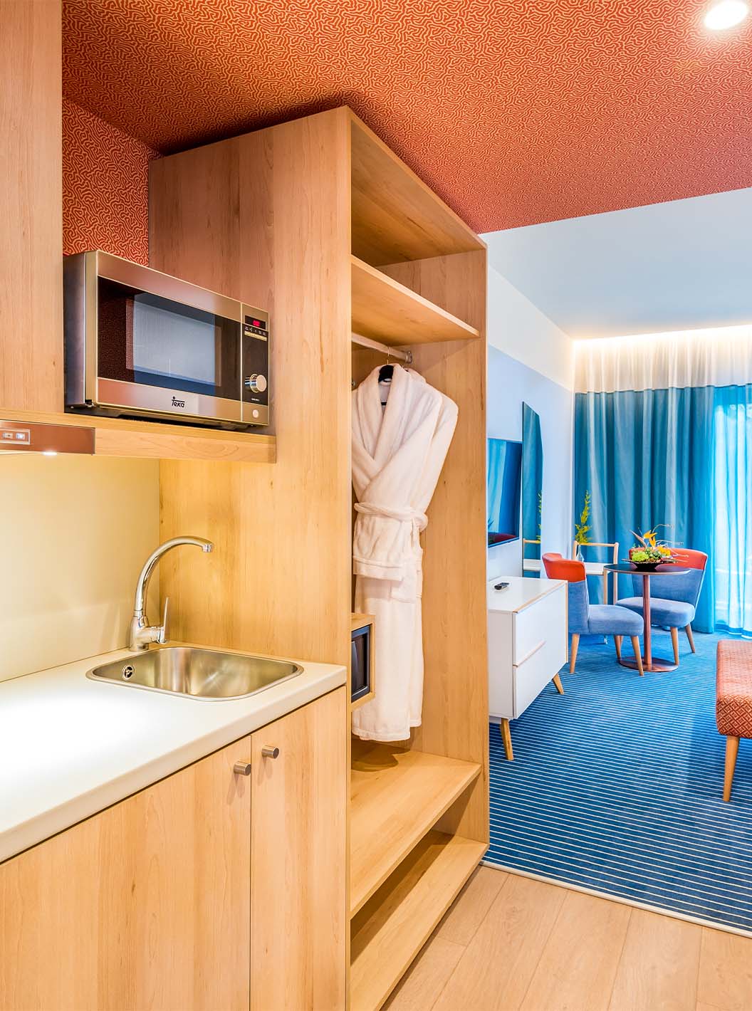 The Deluxe Studio at Pestana Casino Studios has a kitchen with a microwave and sink and a double bed